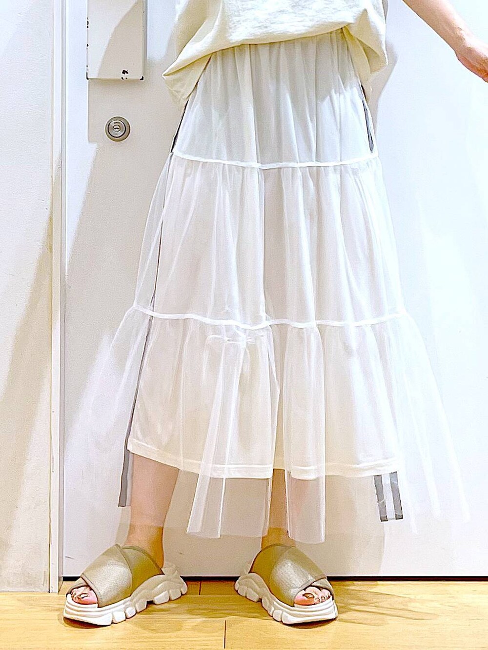 ベージュ系のサンダル、ベージュ系のTシャツ/カットソー、ホワイト系のショルダーバッグを着用したレディースの夏コーディネートの8枚目の写真