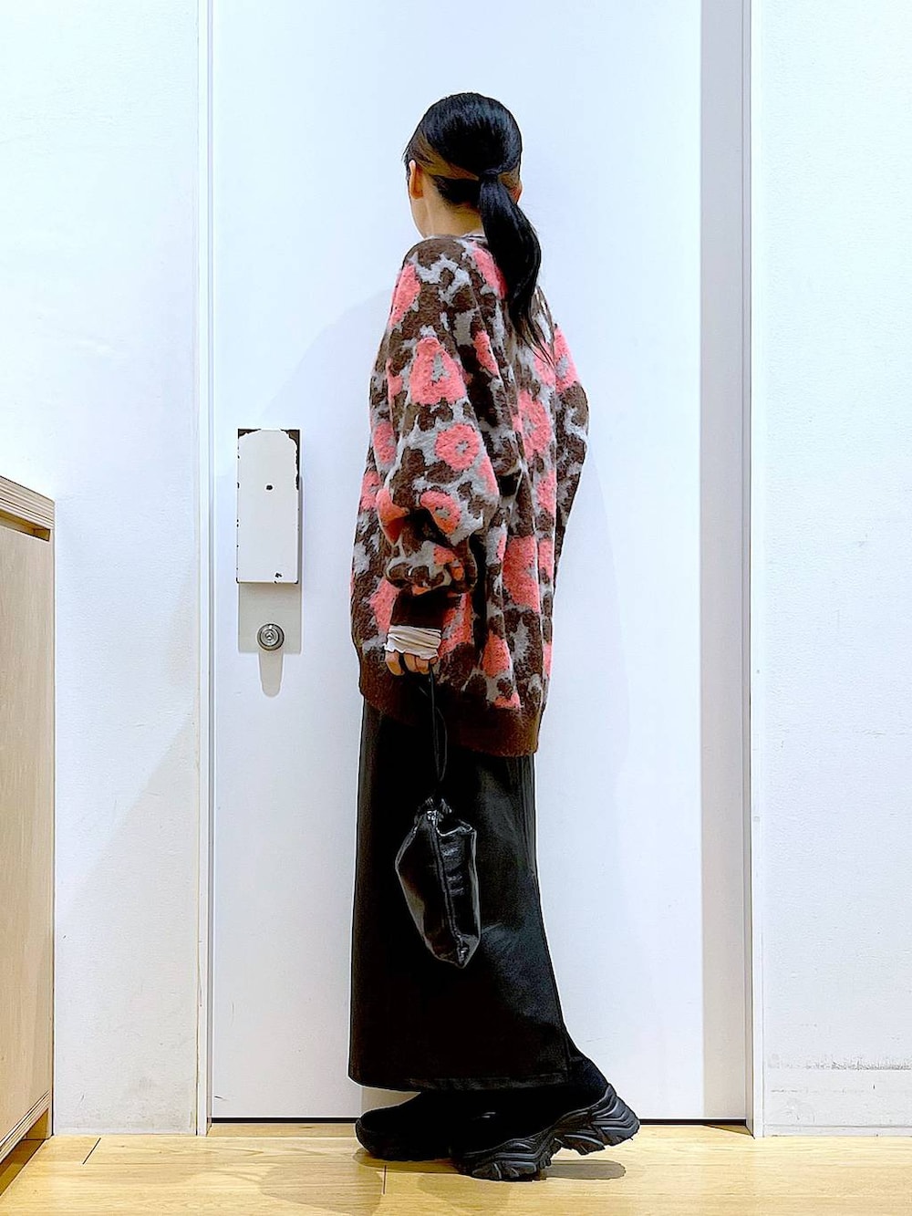 グレー系のTシャツ/カットソー、ブラック系のブーツ、ブラック系のスカートを着用したレディースの冬コーディネートの3枚目の写真