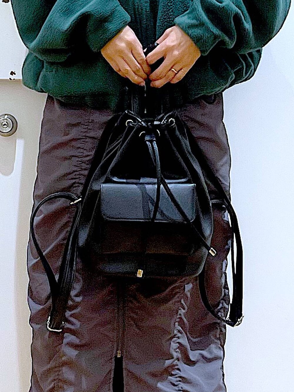 ブラック系のバックパック/リュック、グレー系のスカート、ブラック系のブーツを着用したレディースの冬コーディネートの9枚目の写真