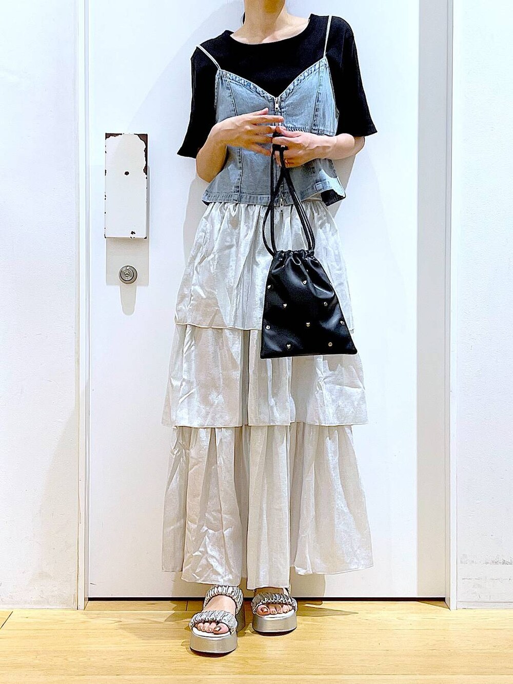 シルバー系のサンダル、ブラック系のショルダーバッグ、ブラック系のTシャツ/カットソーを着用したレディースの夏コーディネートの6枚目の写真