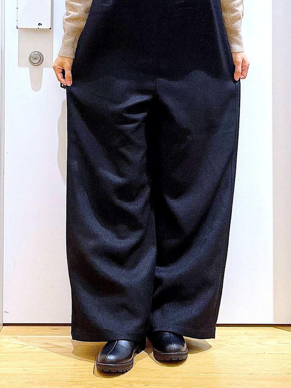 ベージュ系のニット/セーター、ブラック系のブーツ、ブラウン系のクラッチバッグを着用したレディースの冬コーディネートの8枚目の写真