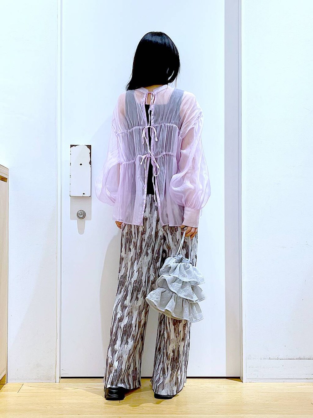 シルバー系のショルダーバッグ、パープル系のシャツ/ブラウス、ブラック系のサンダルを着用したレディースの夏コーディネートの5枚目の写真