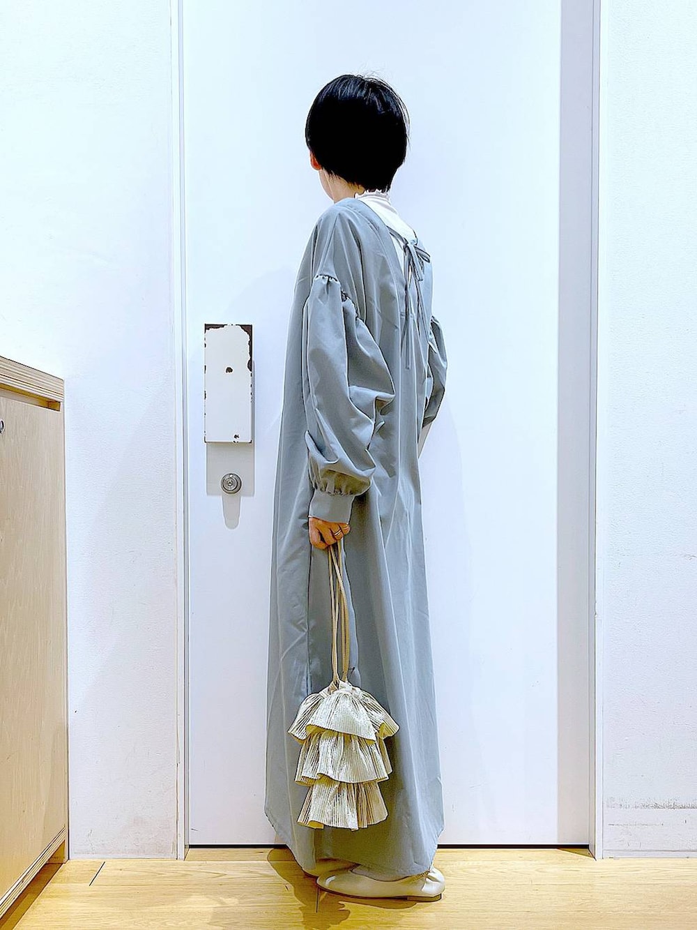 ベージュ系のTシャツ/カットソー、ホワイト系のパンプス、ベージュ系のショルダーバッグを着用したレディースの春コーディネートの3枚目の写真