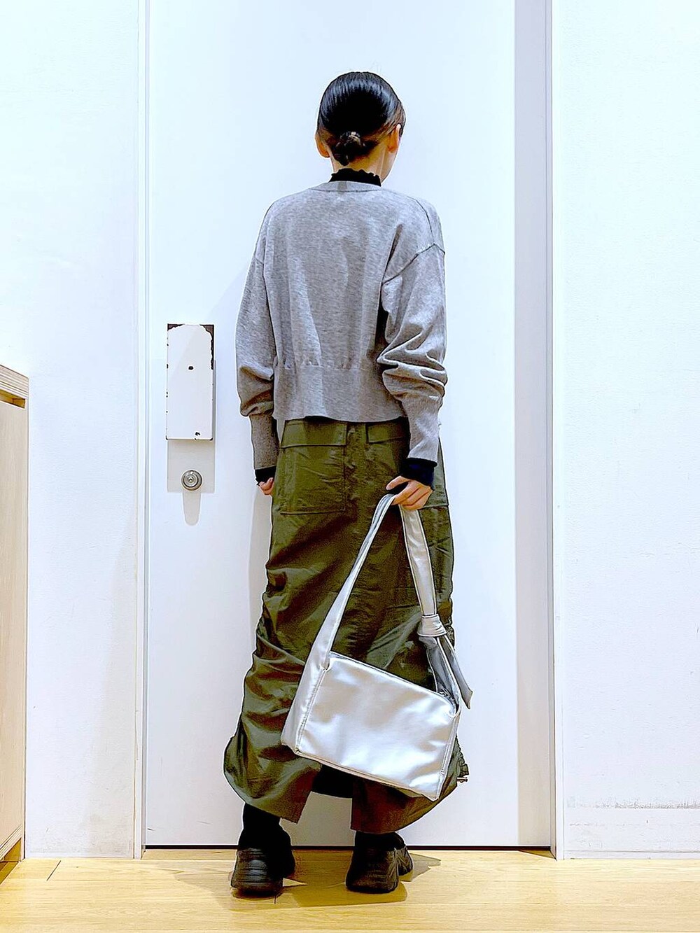 ブラック系のTシャツ/カットソー、グレー系のカーディガン/ボレロ、ブラック系のブーツを着用したレディースの冬コーディネートの5枚目の写真