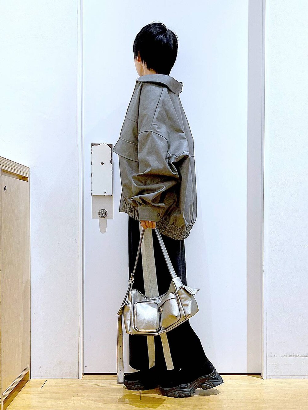 ブラック系のスカート、グレー系のブルゾン、ブラック系のブーツを着用したレディースの冬コーディネートの3枚目の写真