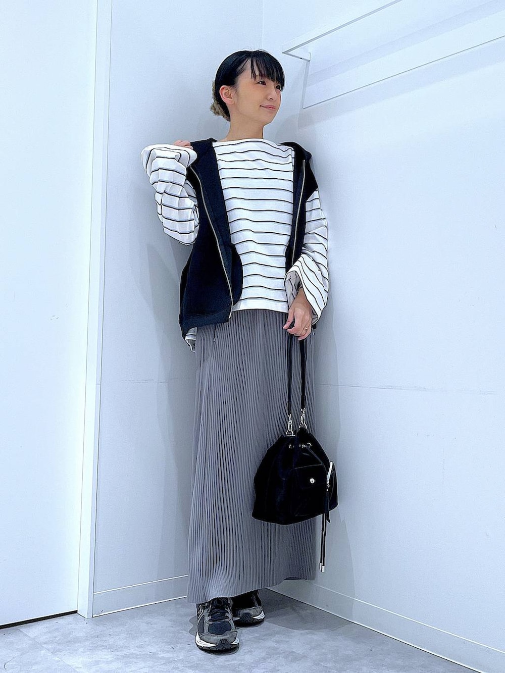 ブラック系のショルダーバッグ、ホワイト系のTシャツ/カットソー、グレー系のスカートを着用したレディースの春コーディネートの2枚目の写真