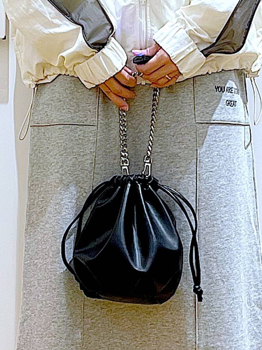 ブラック系のブーツ、ブラック系のショルダーバッグ、グレー系のスカートを着用したレディースの春コーディネートの9枚目の写真