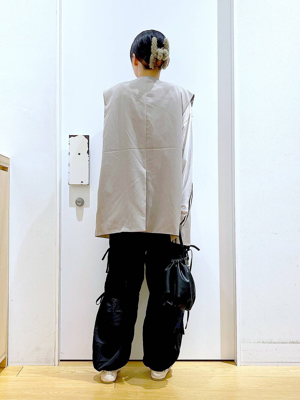 ブラック系のショルダーバッグ、ホワイト系のパンプス、ブラック系のその他パンツを着用したレディースの秋コーディネートの5枚目の写真