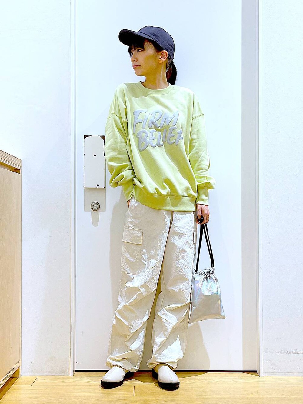 イエロー系のスウェット、ベージュ系のブーツ、その他のショルダーバッグを着用したレディースの春コーディネートの2枚目の写真