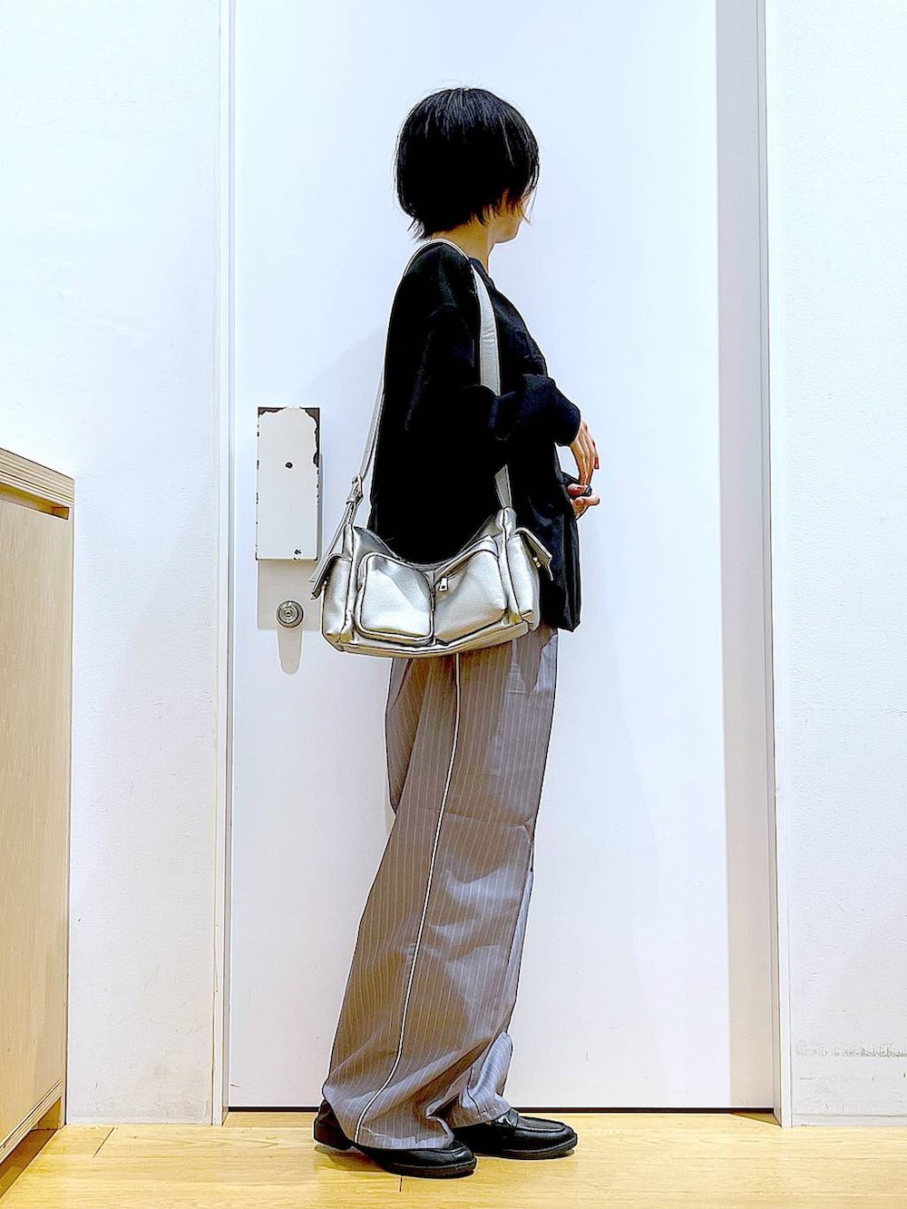 グレー系のスラックス、ブラック系のローファー、その他のショルダーバッグを着用したレディースの秋コーディネートの4枚目の写真