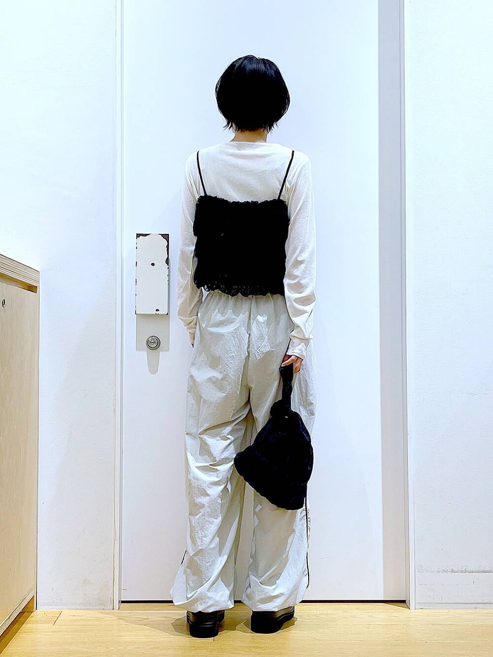 ブラック系のブーツ、ブラック系のショルダーバッグ、ホワイト系のTシャツ/カットソーを着用したレディースの秋コーディネートの5枚目の写真