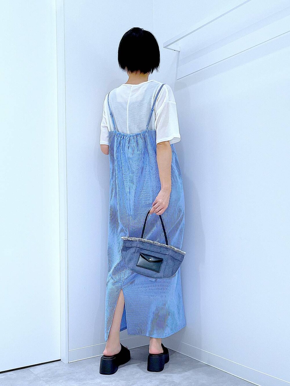 ブルー系のショルダーバッグ、ブラック系のサンダル、ホワイト系のTシャツ/カットソーを着用したレディースの夏コーディネートの5枚目の写真