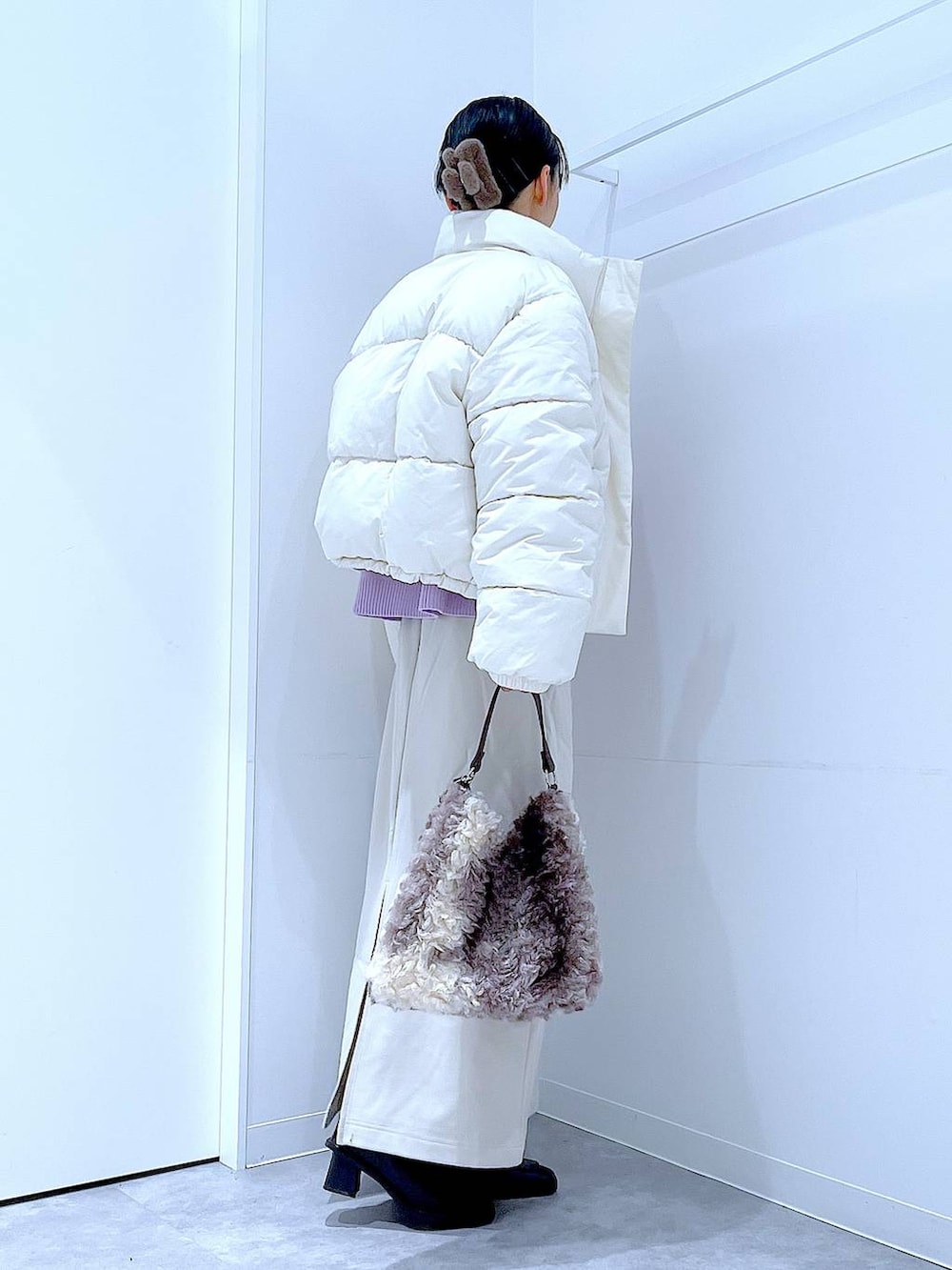 ホワイト系のブルゾン、ベージュ系のスカート、ブラック系のブーツを着用したレディースの冬コーディネートの4枚目の写真