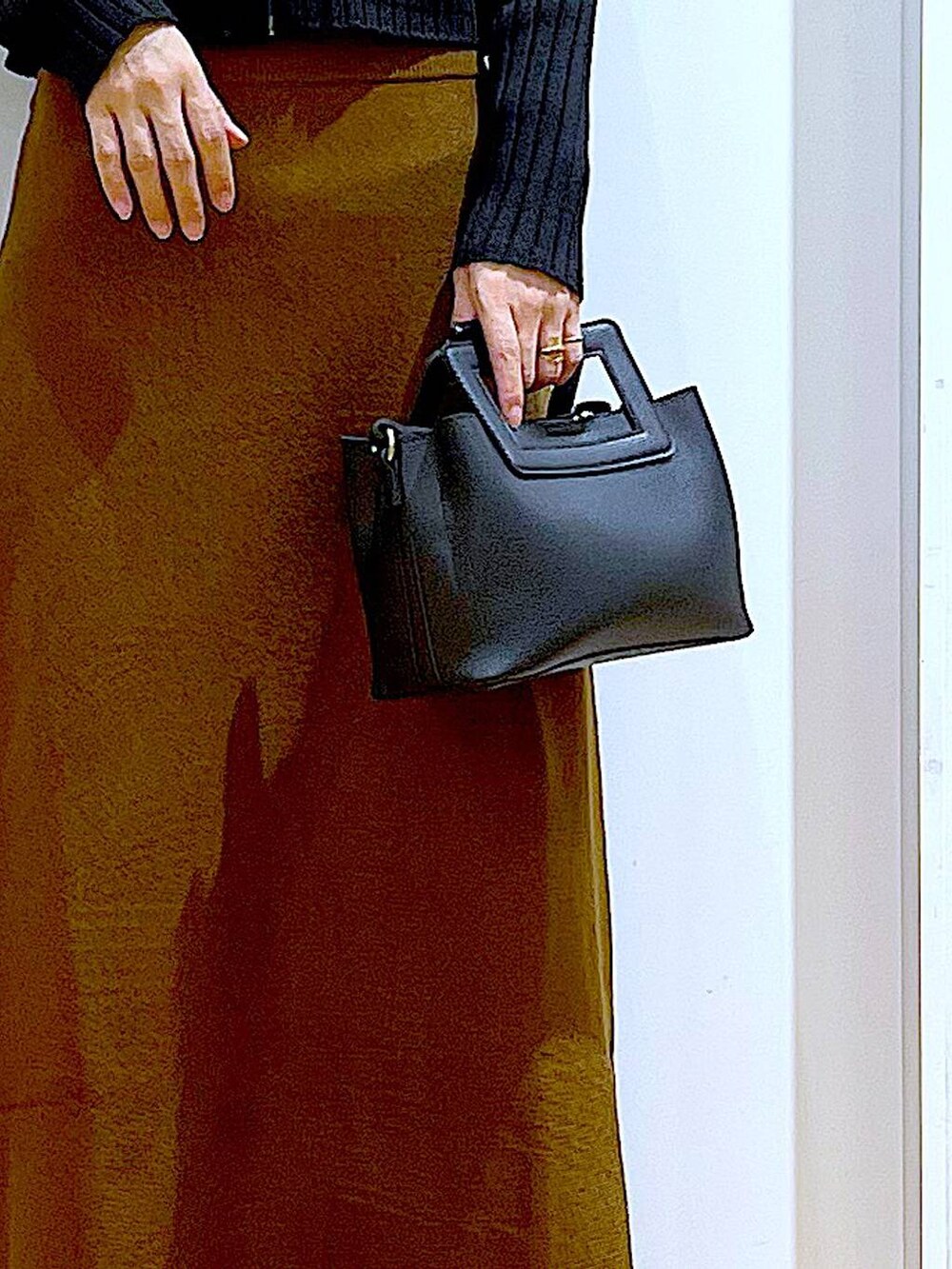 ブラック系のカーディガン/ボレロ、ブラウン系のスカート、ベージュ系のブーツを着用したレディースの冬コーディネートの9枚目の写真