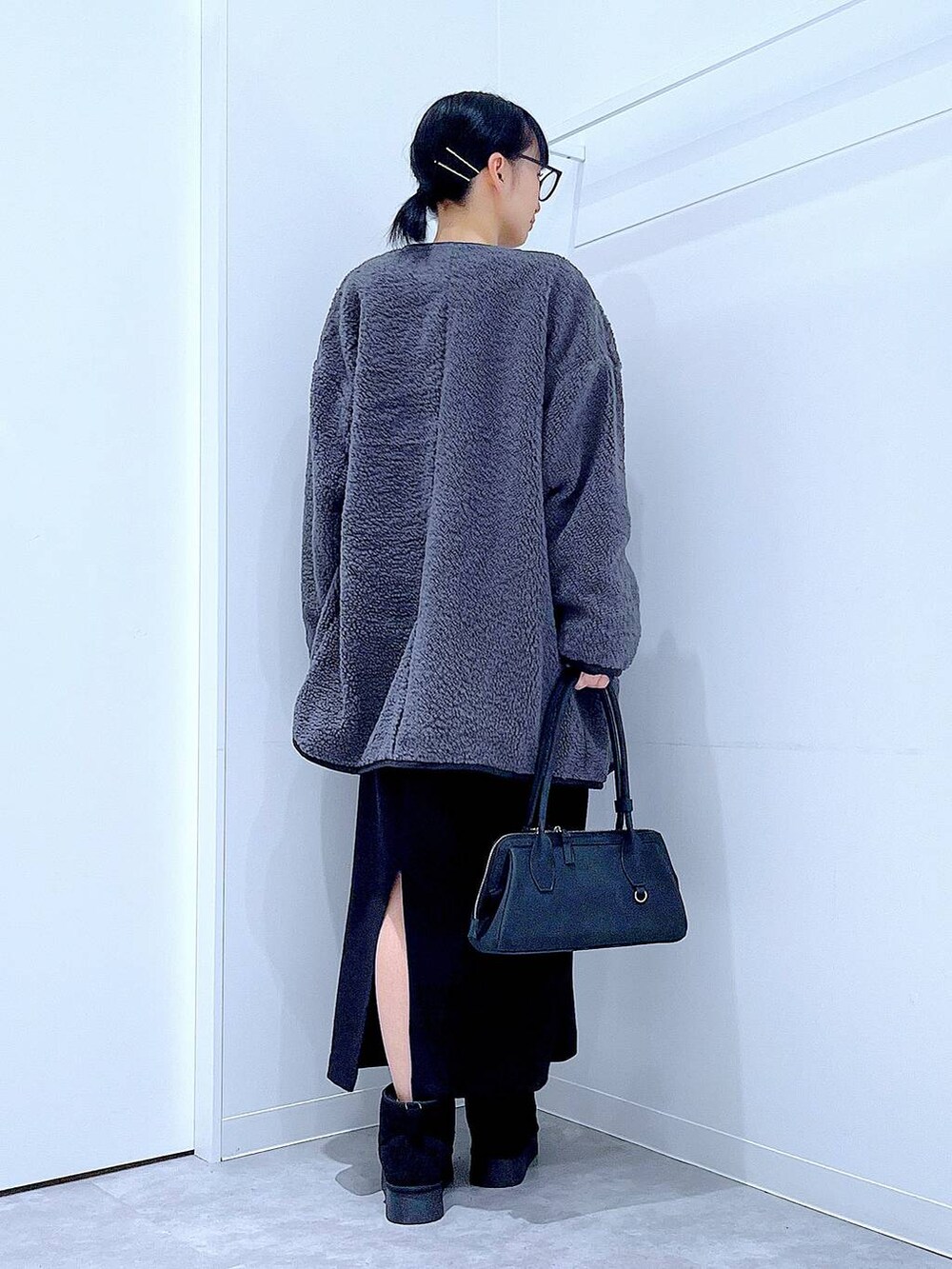 ブラック系のスカート、グレー系のブルゾン、ブラック系のブーツを着用したレディースの秋コーディネートの5枚目の写真