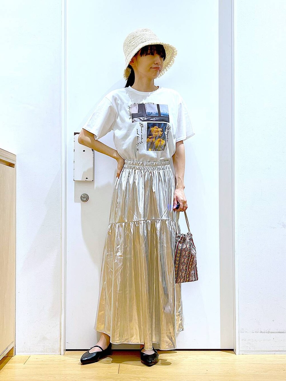 ピンク系のショルダーバッグ、シルバー系のスカート、ホワイト系のTシャツ/カットソーを着用したレディースの夏コーディネートの2枚目の写真