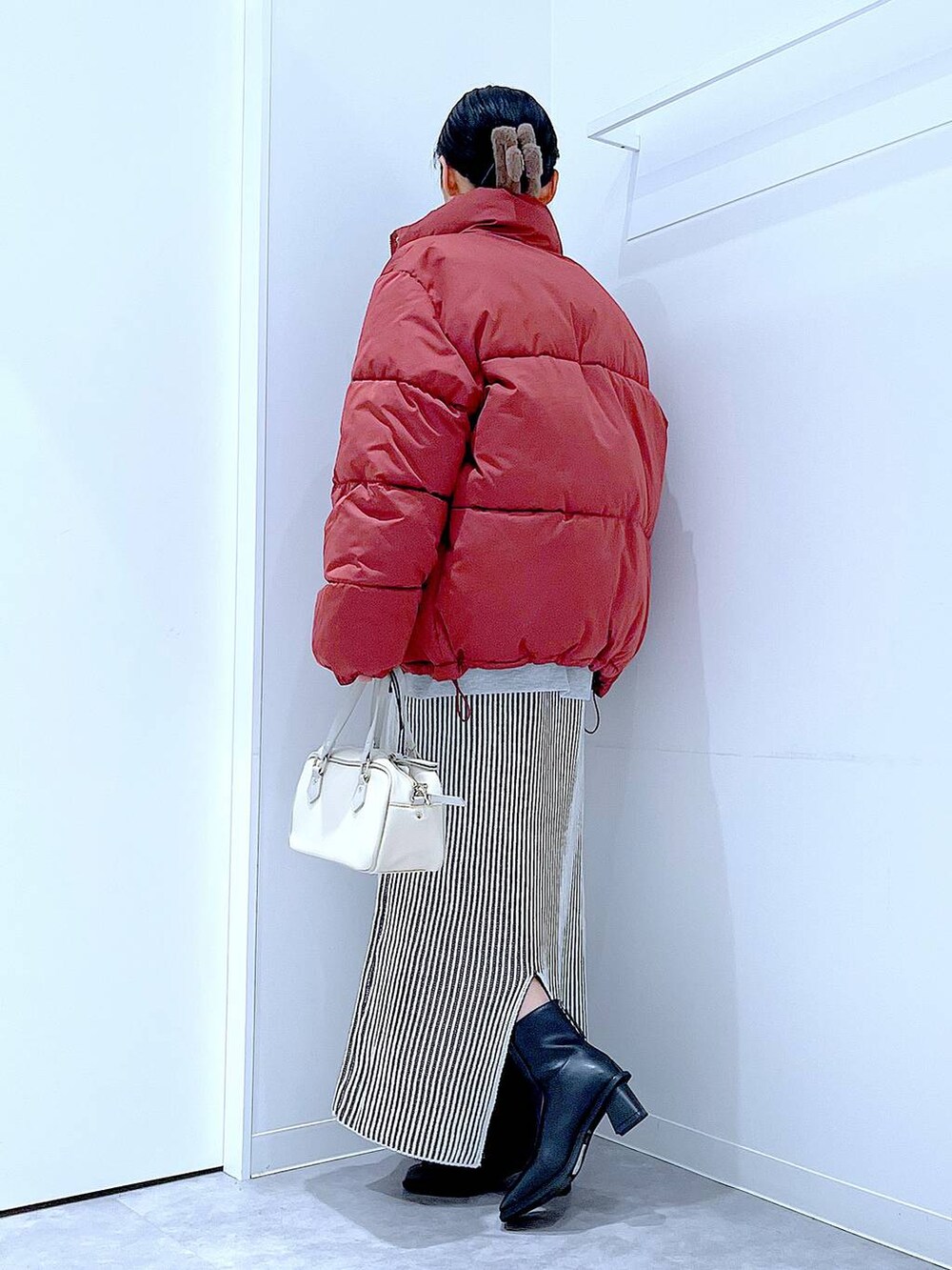 ブラウン系のブルゾン、ベージュ系のスカート、ブラック系のブーツを着用したレディースの冬コーディネートの3枚目の写真