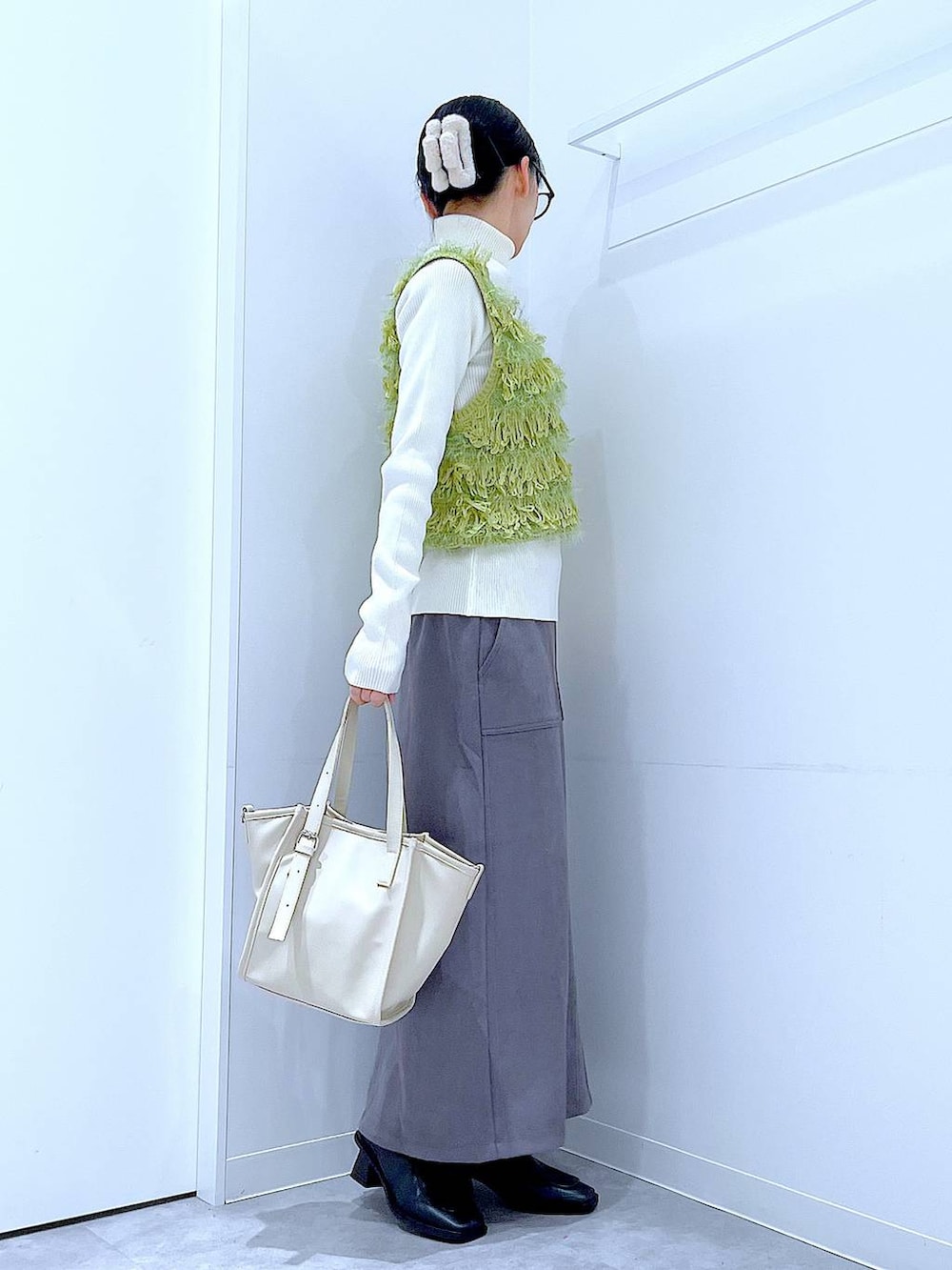 ブラック系のブーツ、グレー系のスカート、ベージュ系のニット/セーターを着用したレディースの冬コーディネートの4枚目の写真