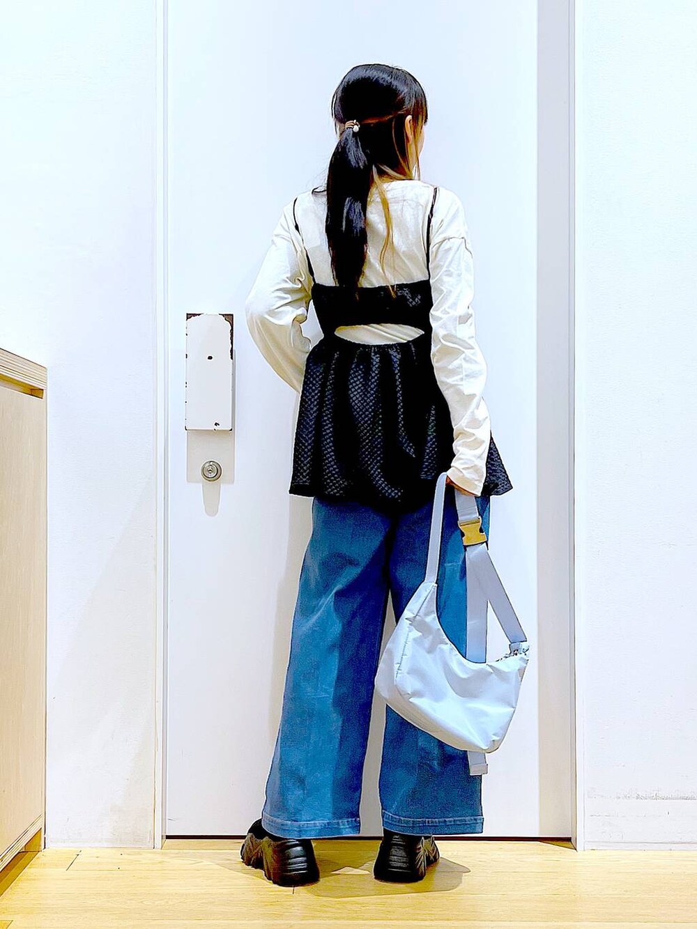 ブルー系のデニムパンツ、ホワイト系のTシャツ/カットソー、ブルー系のショルダーバッグを着用したレディースの春コーディネートの6枚目の写真