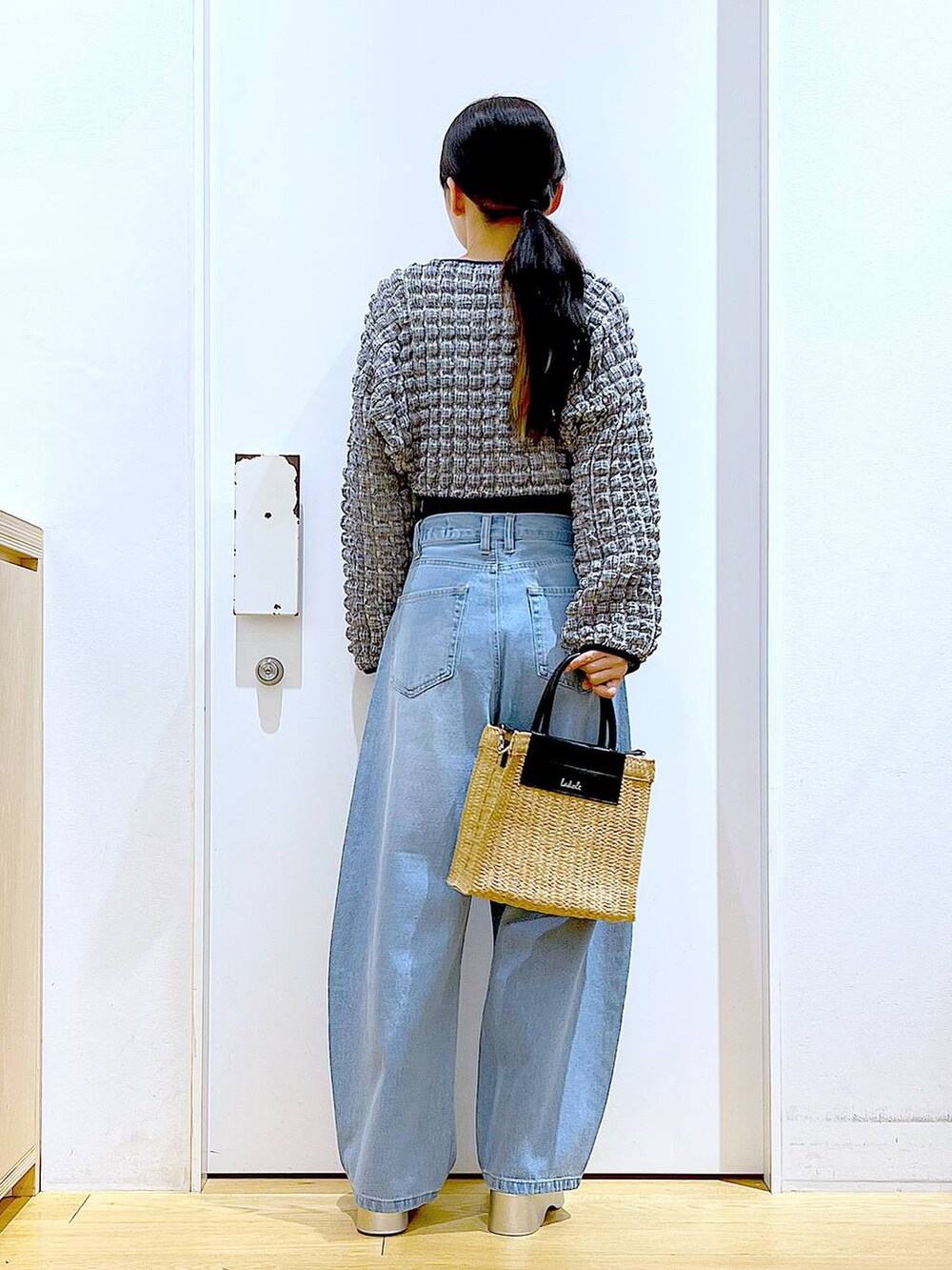 ブルー系のデニムパンツ、ブラック系のTシャツ/カットソー、ベージュ系のショルダーバッグを着用したレディースの夏コーディネートの5枚目の写真