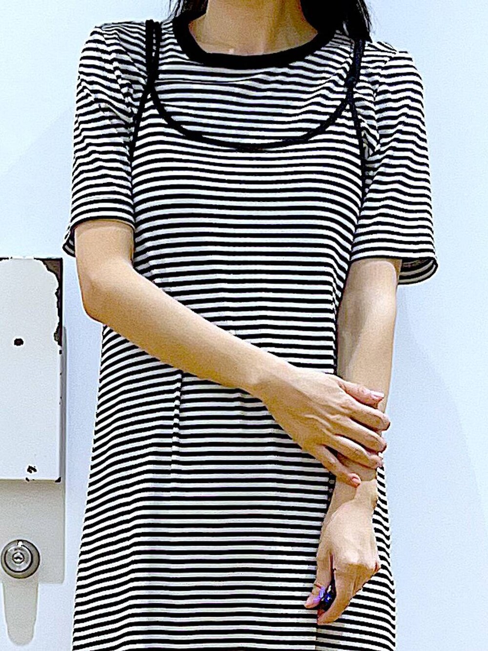 ブラック系のショルダーバッグ、ブラック系のサンダル、ブラック系のワンピースを着用したレディースの夏コーディネートの7枚目の写真