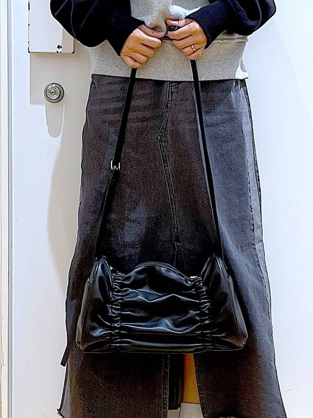 シルバー系のローファー、ブラック系のニット/セーター、ブラック系のショルダーバッグを着用したレディースの冬コーディネートの9枚目の写真