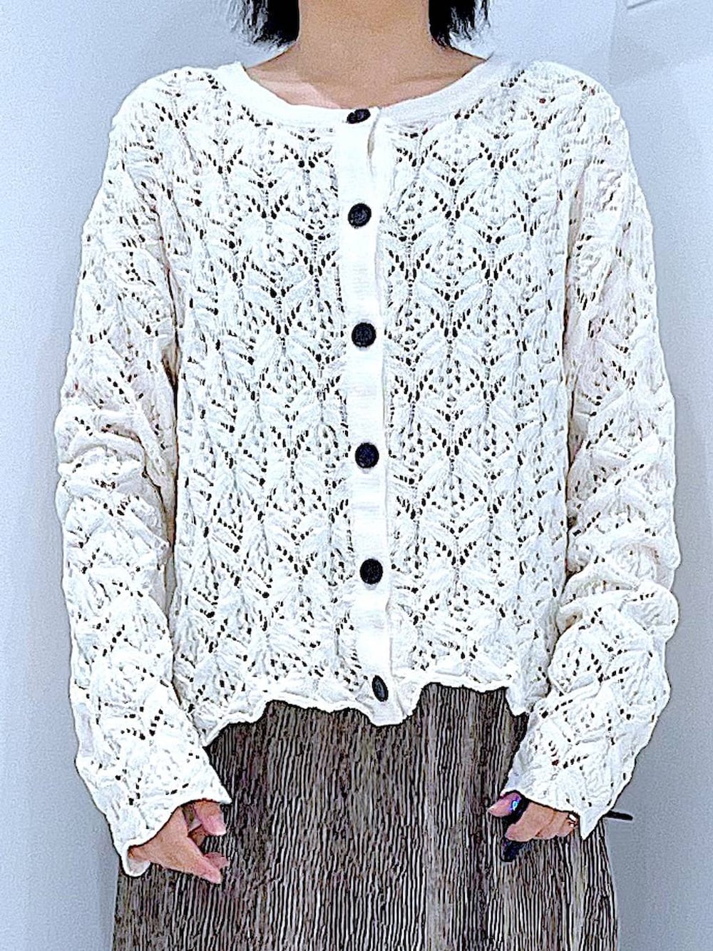 ブラック系のブーツ、ホワイト系のショルダーバッグ、ベージュ系のカーディガン/ボレロを着用したレディースの冬コーディネートの7枚目の写真