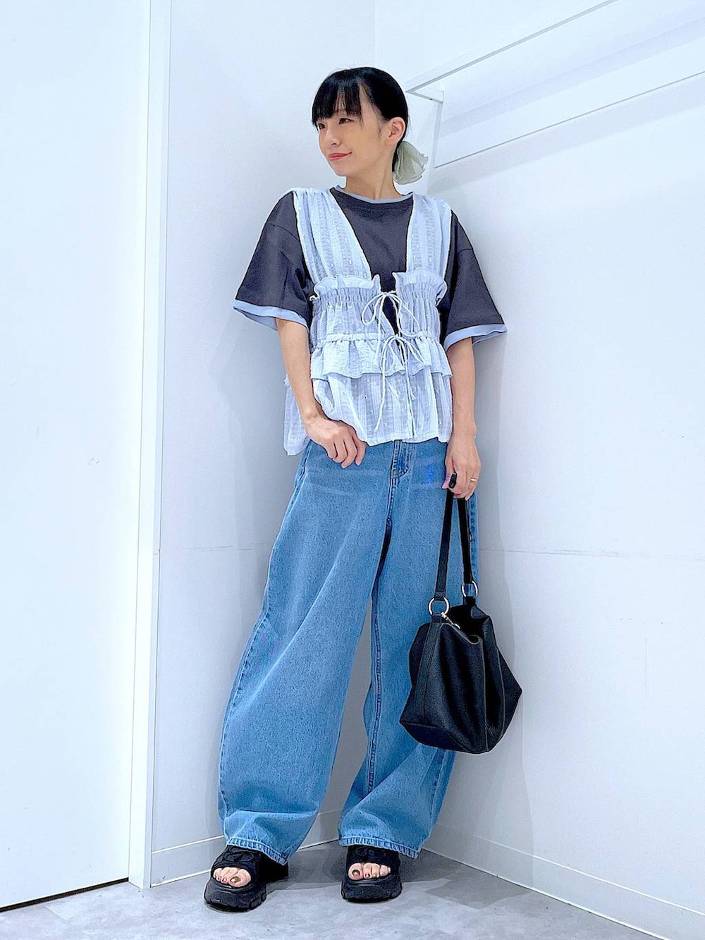 グレー系のTシャツ/カットソー、ブルー系のデニムパンツ、ブルー系のベストを着用したレディースの夏コーディネートの2枚目の写真