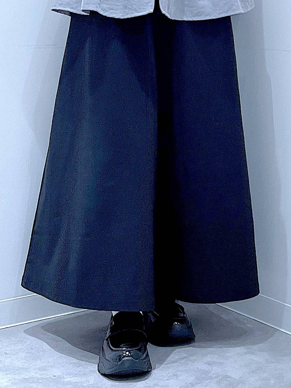 ブラック系のスカート、ブラック系のローファー、ブラウン系のショルダーバッグを着用したレディースの秋コーディネートの8枚目の写真