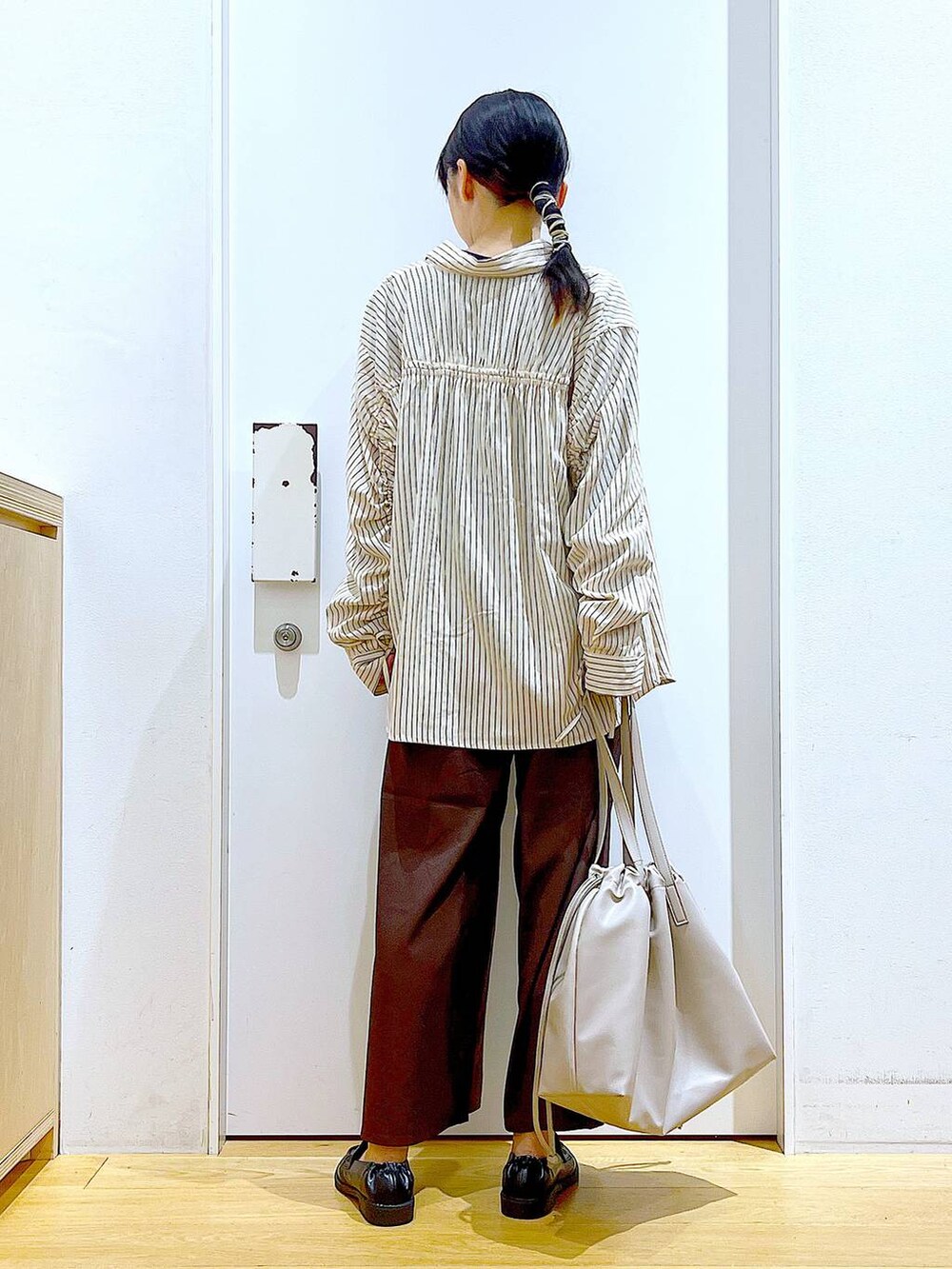 ベージュ系のトートバッグ、ブラック系のローファー、ブラウン系のその他パンツを着用したレディースの秋コーディネートの5枚目の写真