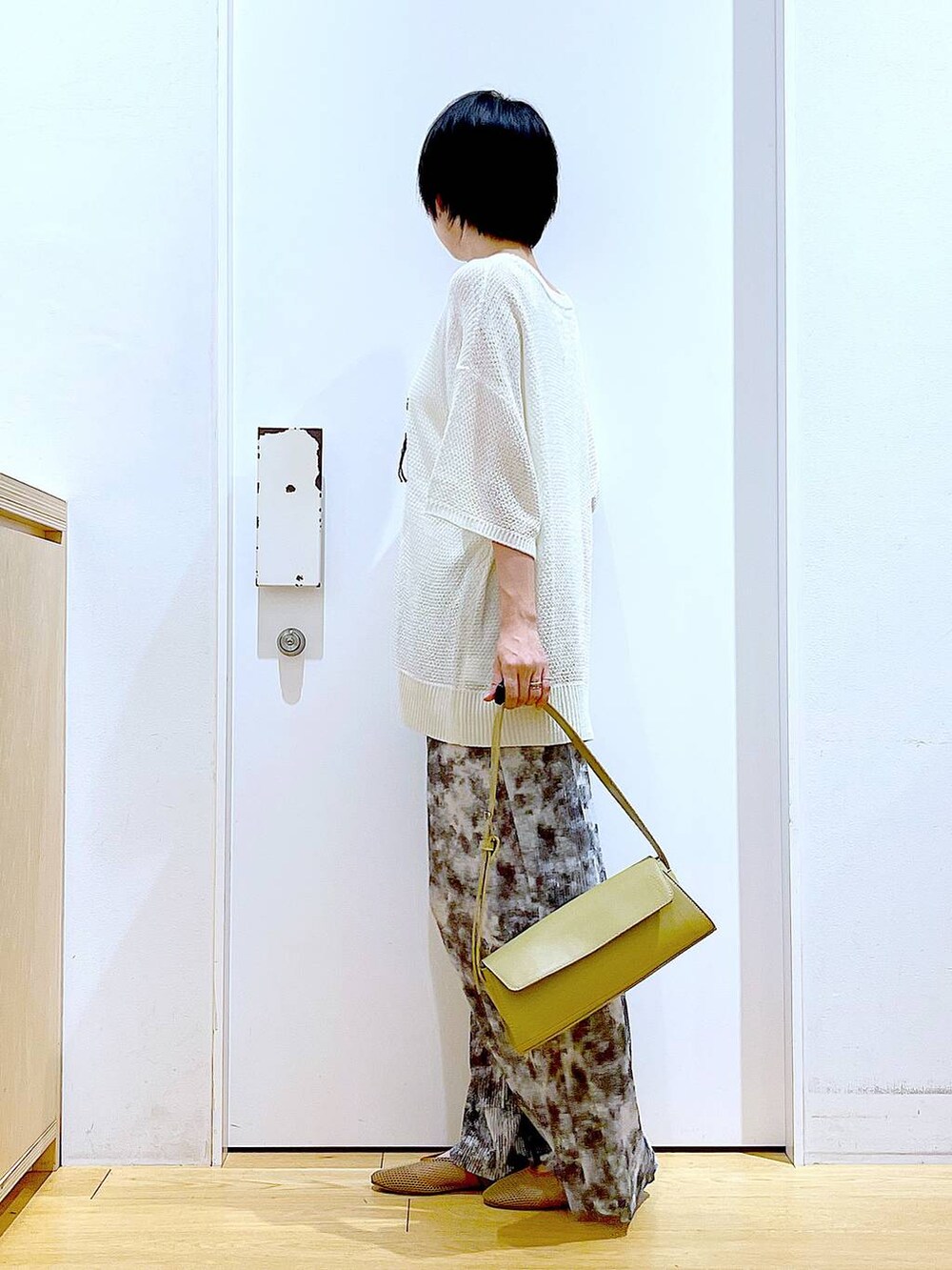 ベージュ系のパンプス、イエロー系のショルダーバッグ、グレー系のその他パンツを着用したレディースの春コーディネートの3枚目の写真