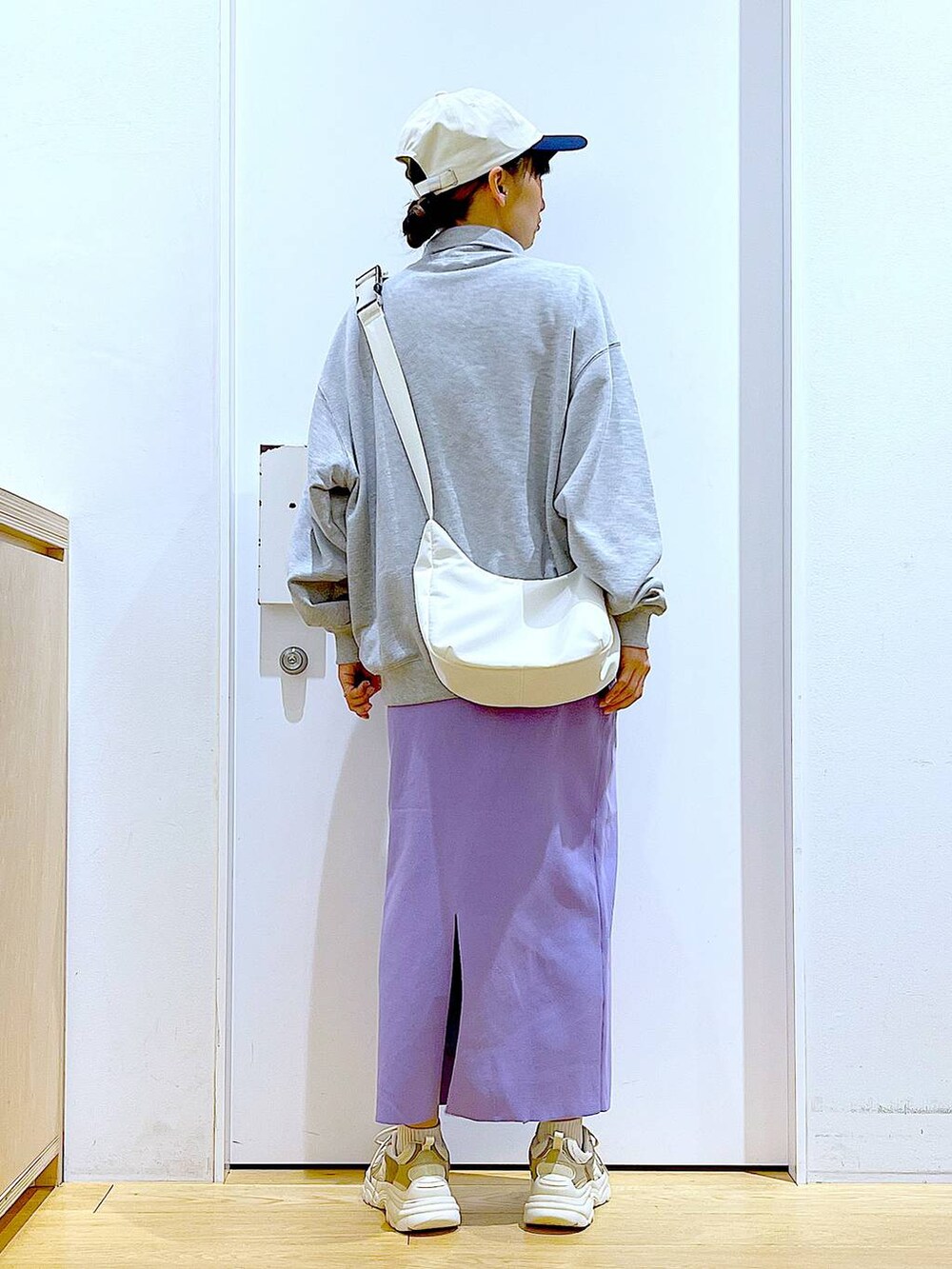 グレー系のスウェット、ベージュ系のスニーカー、ホワイト系のショルダーバッグを着用したレディースの春コーディネートの5枚目の写真