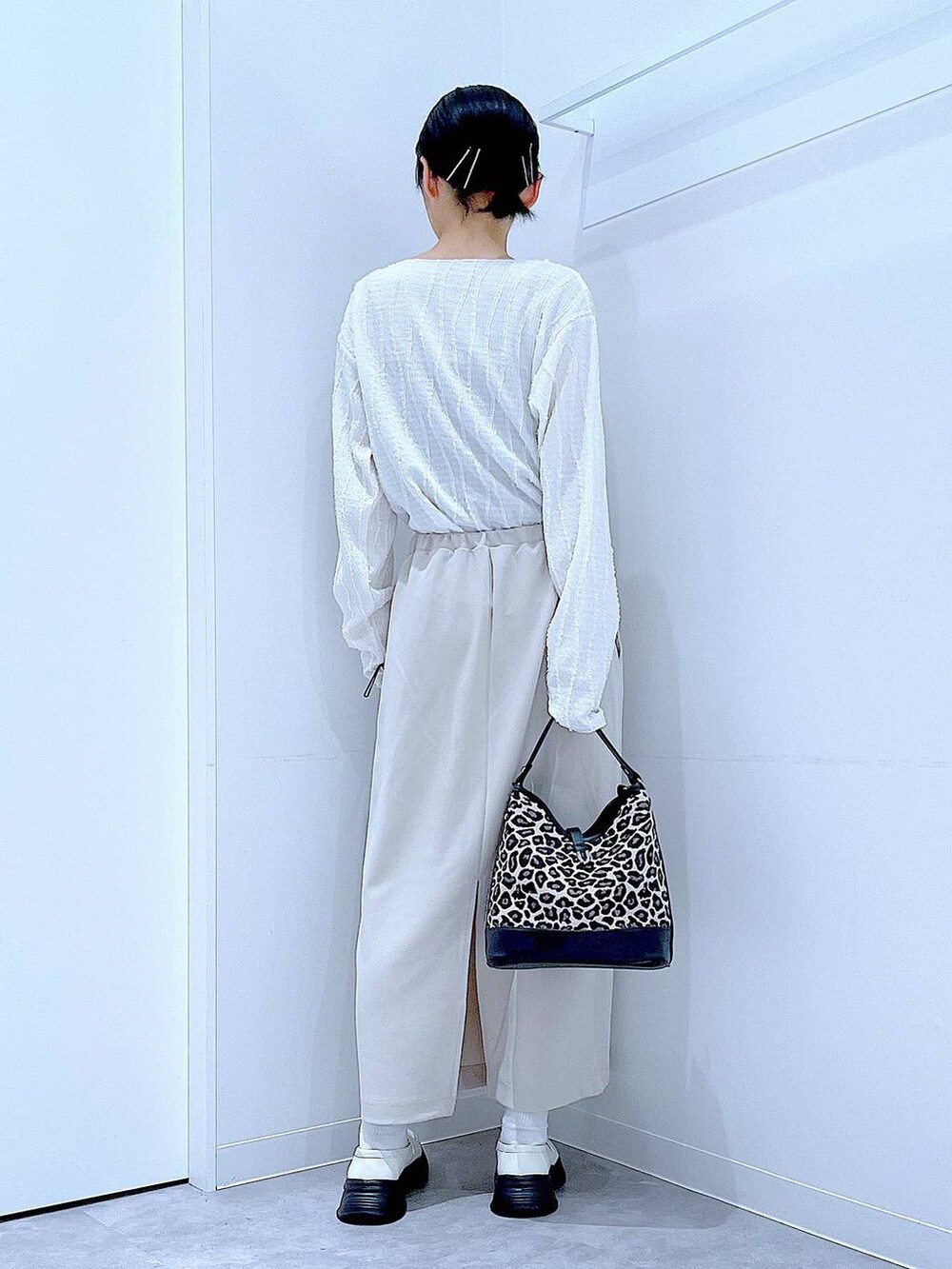 ベージュ系のスカート、ホワイト系のローファー、その他のショルダーバッグを着用したレディースの秋コーディネートの5枚目の写真