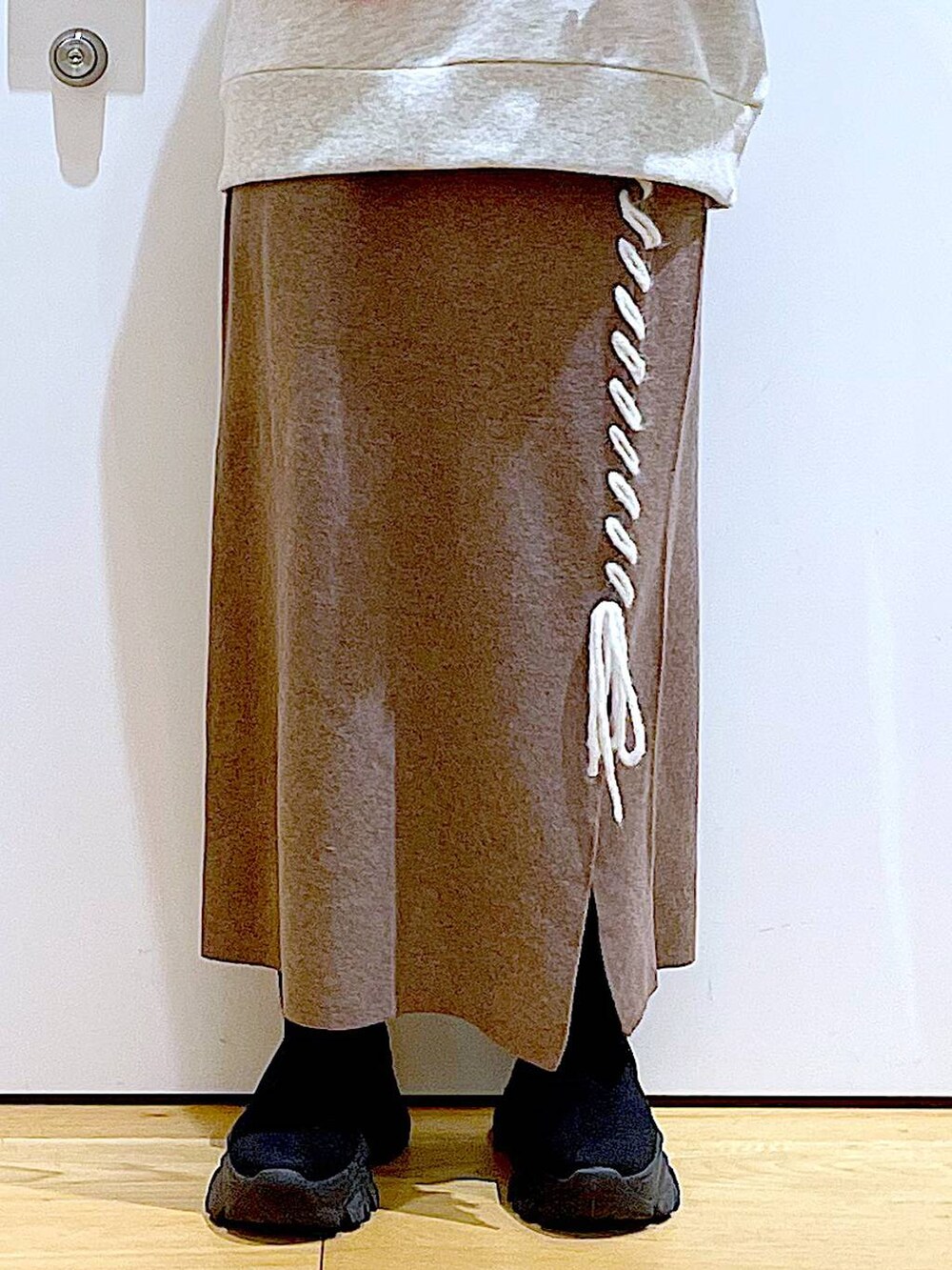 ブラック系のショルダーバッグ、ブラック系のブーツ、ブラウン系のスカートを着用したレディースの冬コーディネートの8枚目の写真