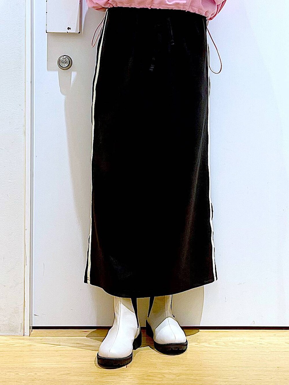 ピンク系のスウェット、ベージュ系のブーツ、ブラック系のショルダーバッグを着用したレディースの春コーディネートの8枚目の写真