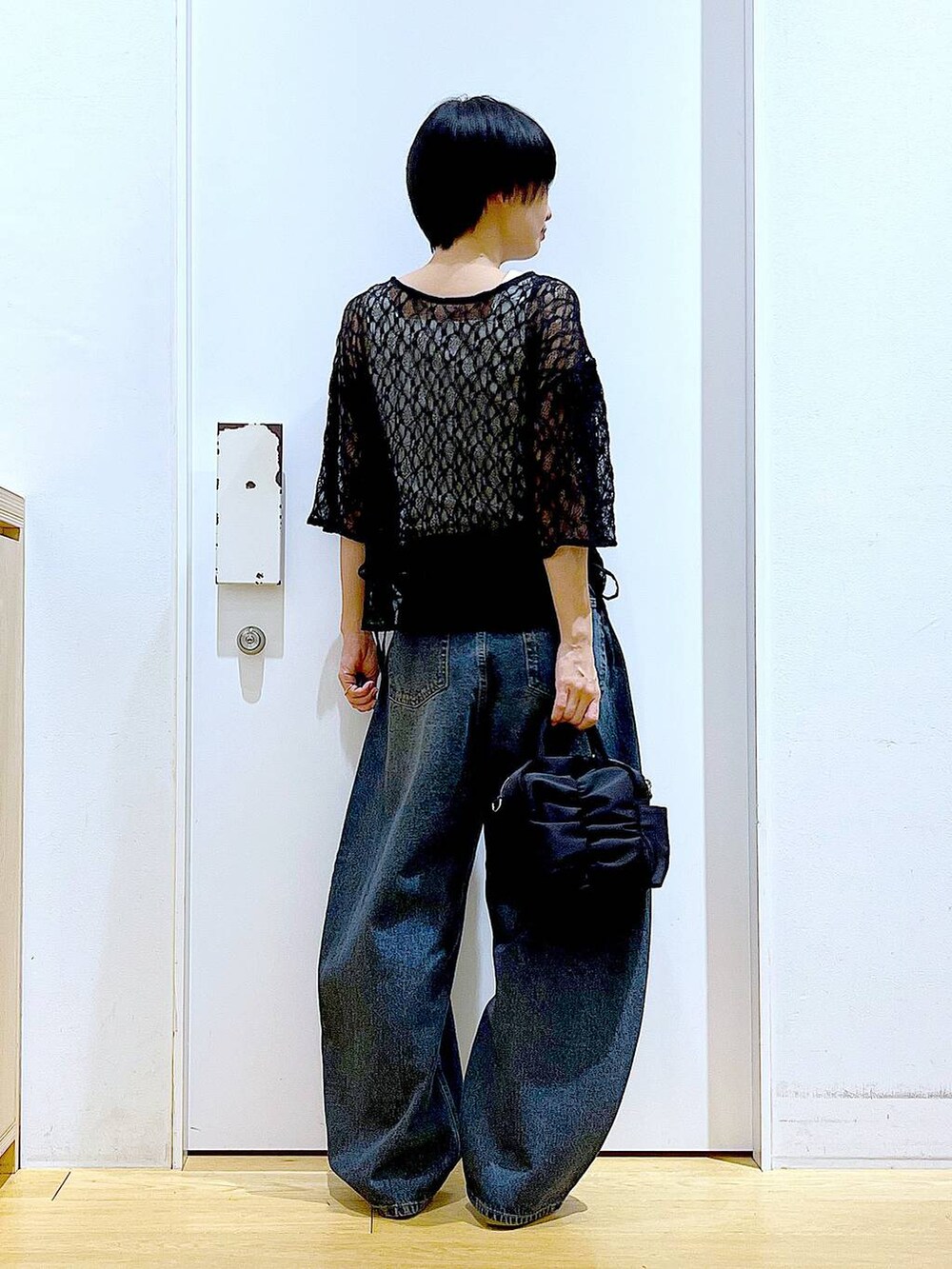 ブルー系のデニムパンツ、シルバー系のパンプス、ブラック系のTシャツ/カットソーを着用したレディースの夏コーディネートの5枚目の写真