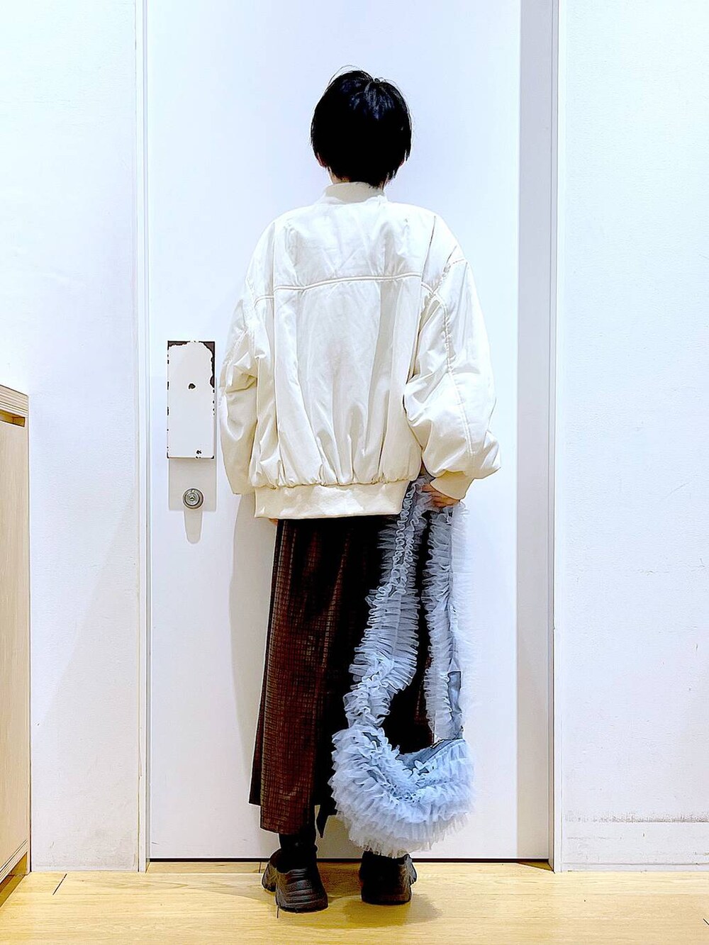 ブラック系のブーツ、グレー系のスウェット、ブラウン系のワンピースを着用したレディースの冬コーディネートの5枚目の写真