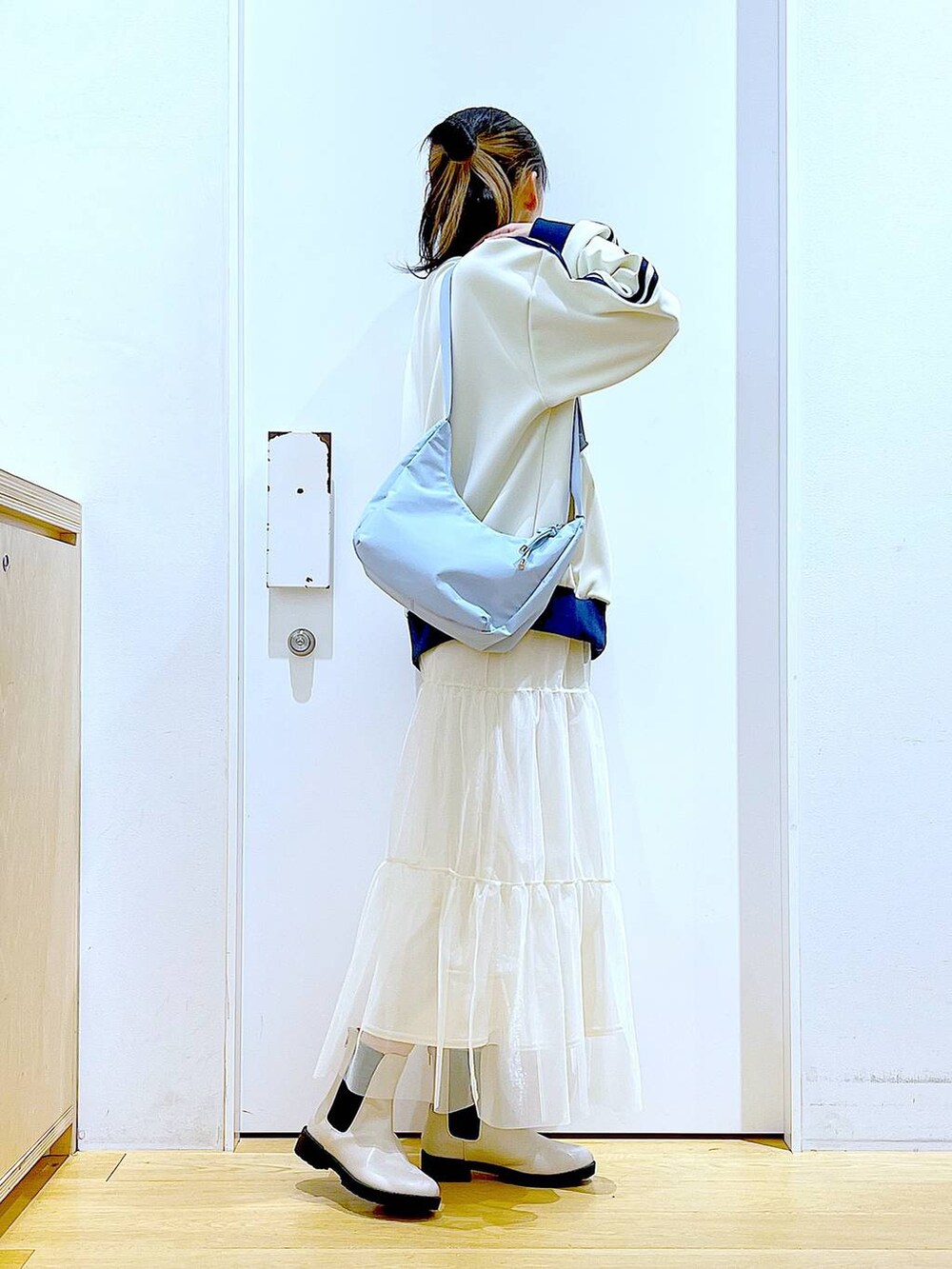 ベージュ系のブーツ、ブルー系のショルダーバッグ、ベージュ系のスウェットを着用したレディースの春コーディネートの4枚目の写真