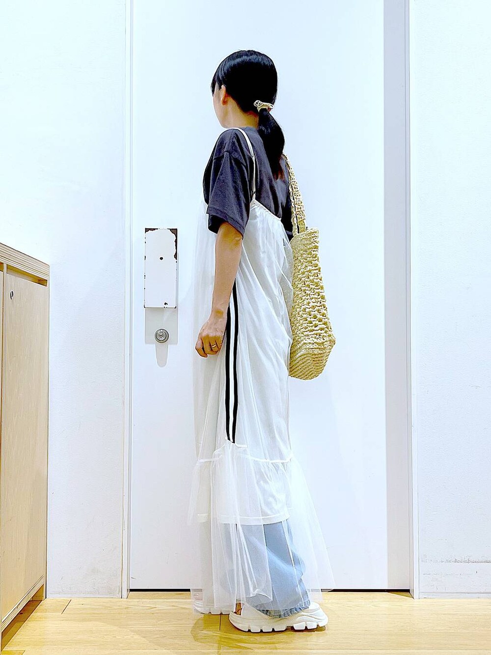 ホワイト系のサンダル、ブルー系のデニムパンツ、ホワイト系のトートバッグを着用したレディースの夏コーディネートの3枚目の写真