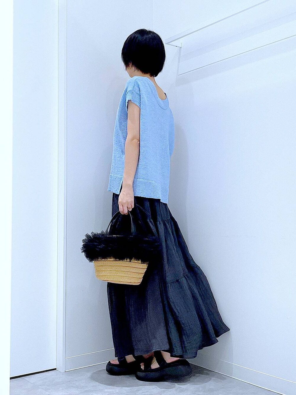 ベージュ系のショルダーバッグ、ブラック系のサンダル、ブルー系のベストを着用したレディースの夏コーディネートの3枚目の写真