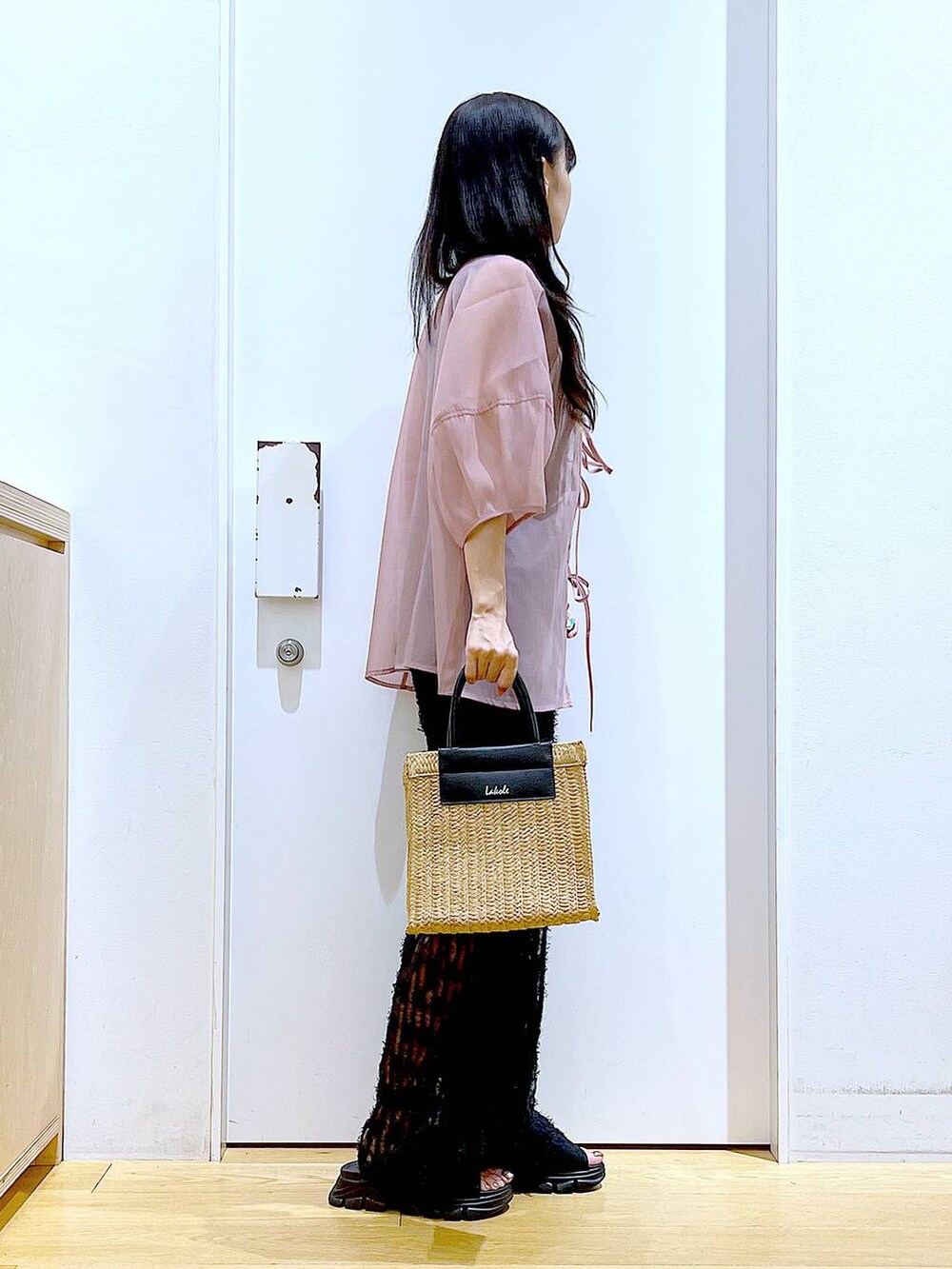 ブラック系のサンダル、ブラック系のニット/セーター、ベージュ系のショルダーバッグを着用したレディースの夏コーディネートの4枚目の写真