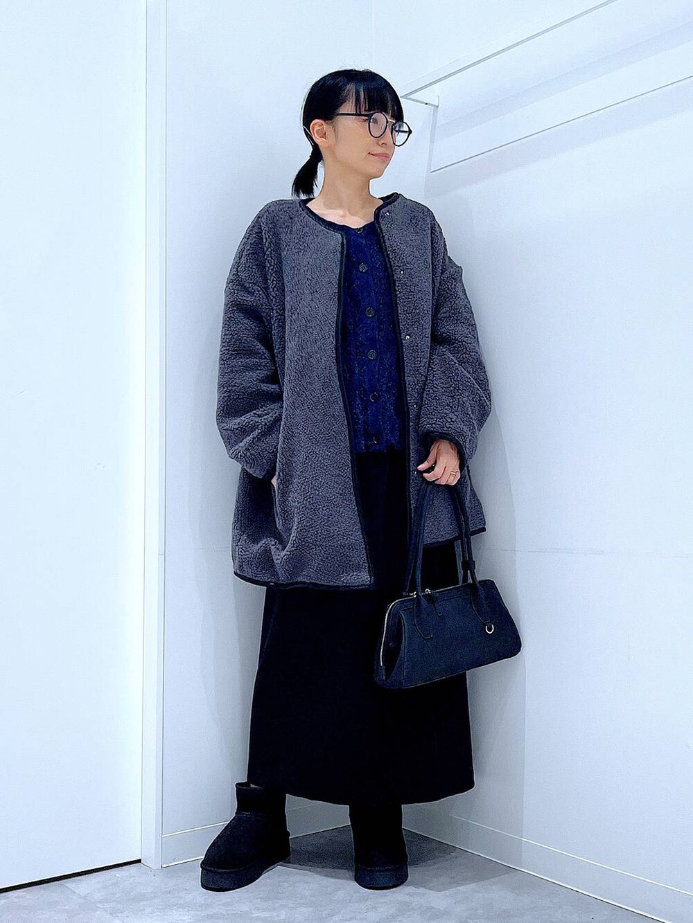 ブラック系のスカート、グレー系のブルゾン、ブラック系のブーツを着用したレディースの秋コーディネートの2枚目の写真