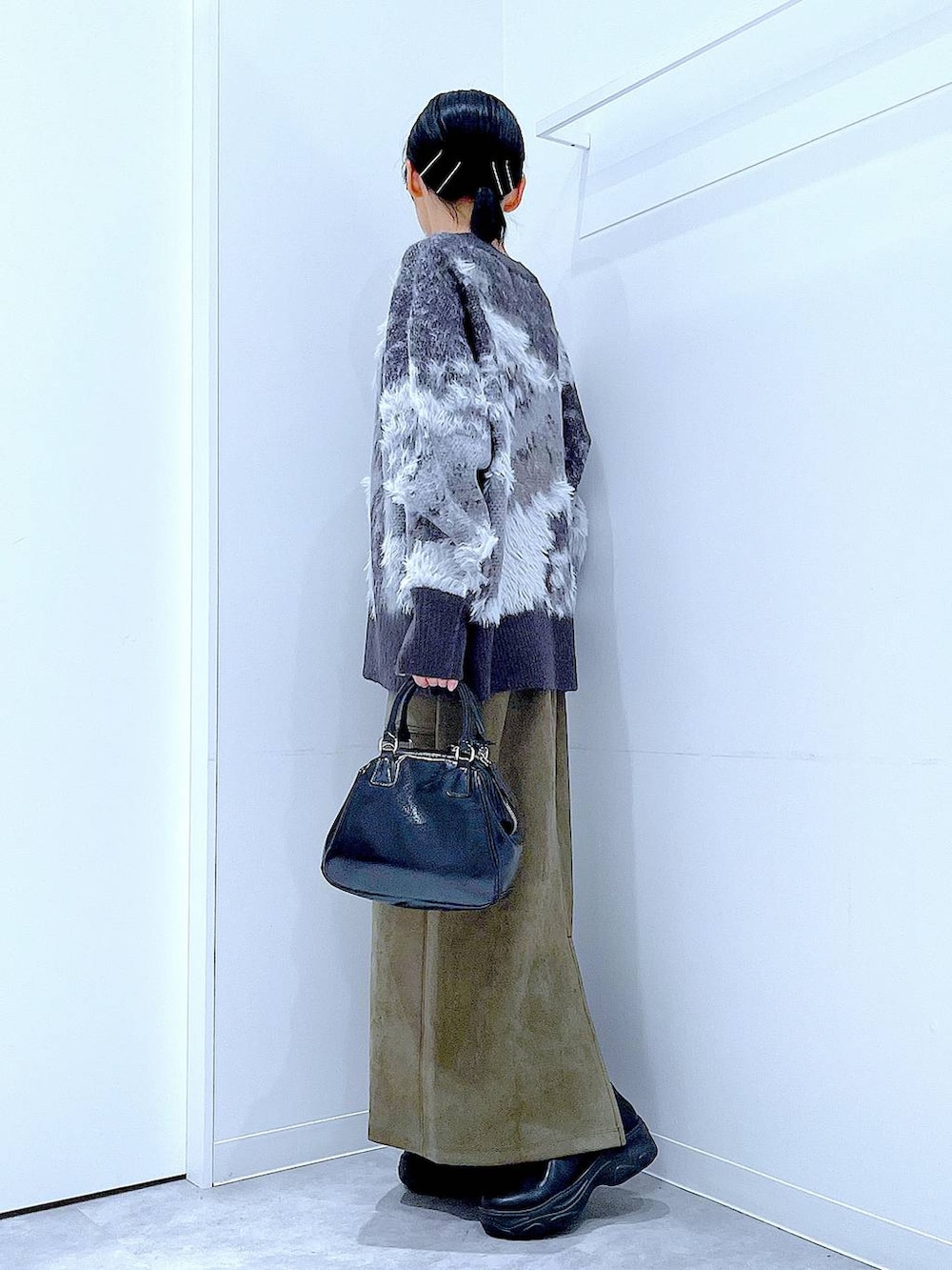 ブラック系のブーツ、ブラック系のニット/セーター、ブラック系のショルダーバッグを着用したレディースの冬コーディネートの3枚目の写真