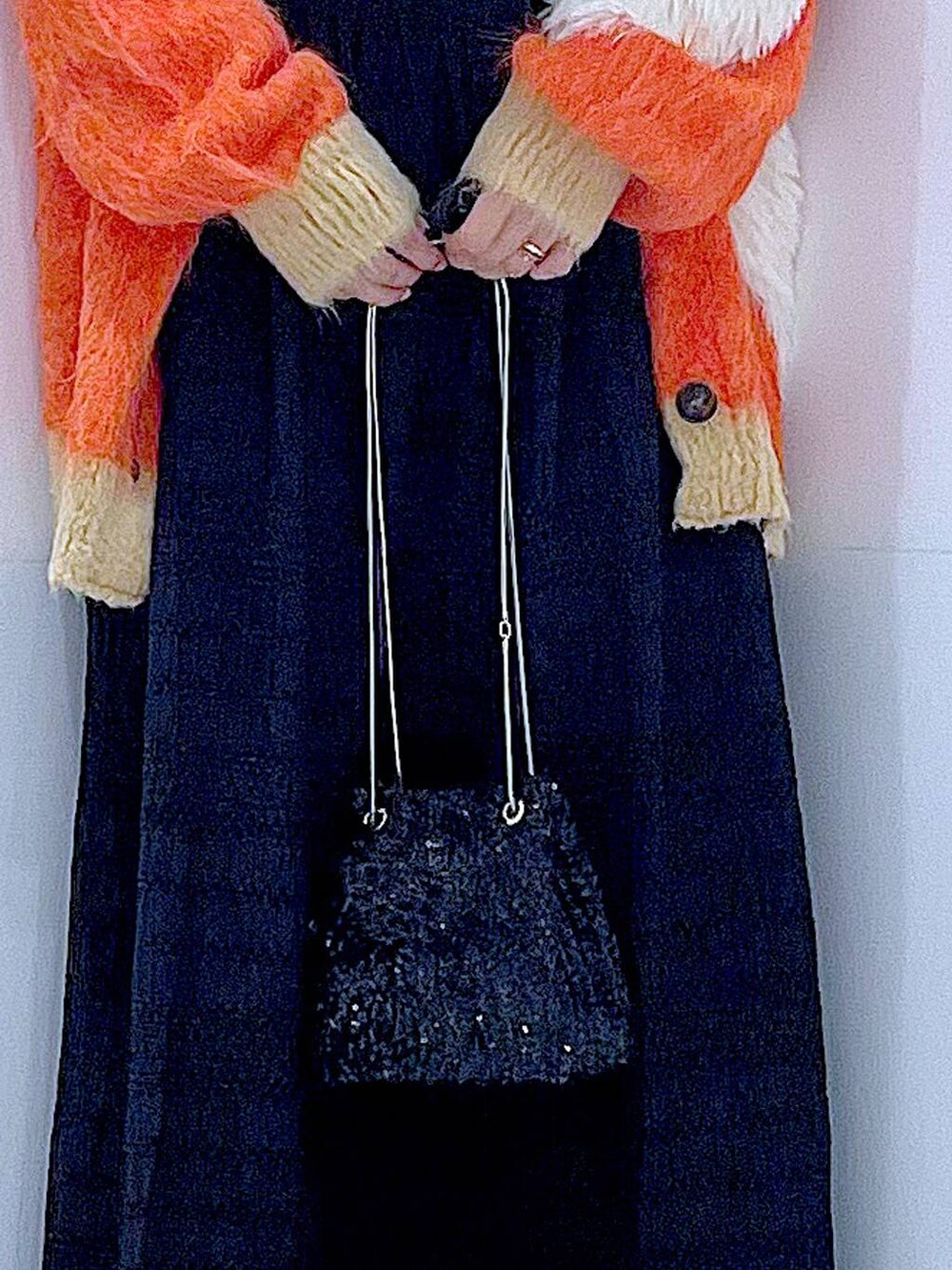 ブラック系のショルダーバッグ、ブラック系のローファー、オレンジ系のカーディガン/ボレロを着用したレディースの秋コーディネートの9枚目の写真