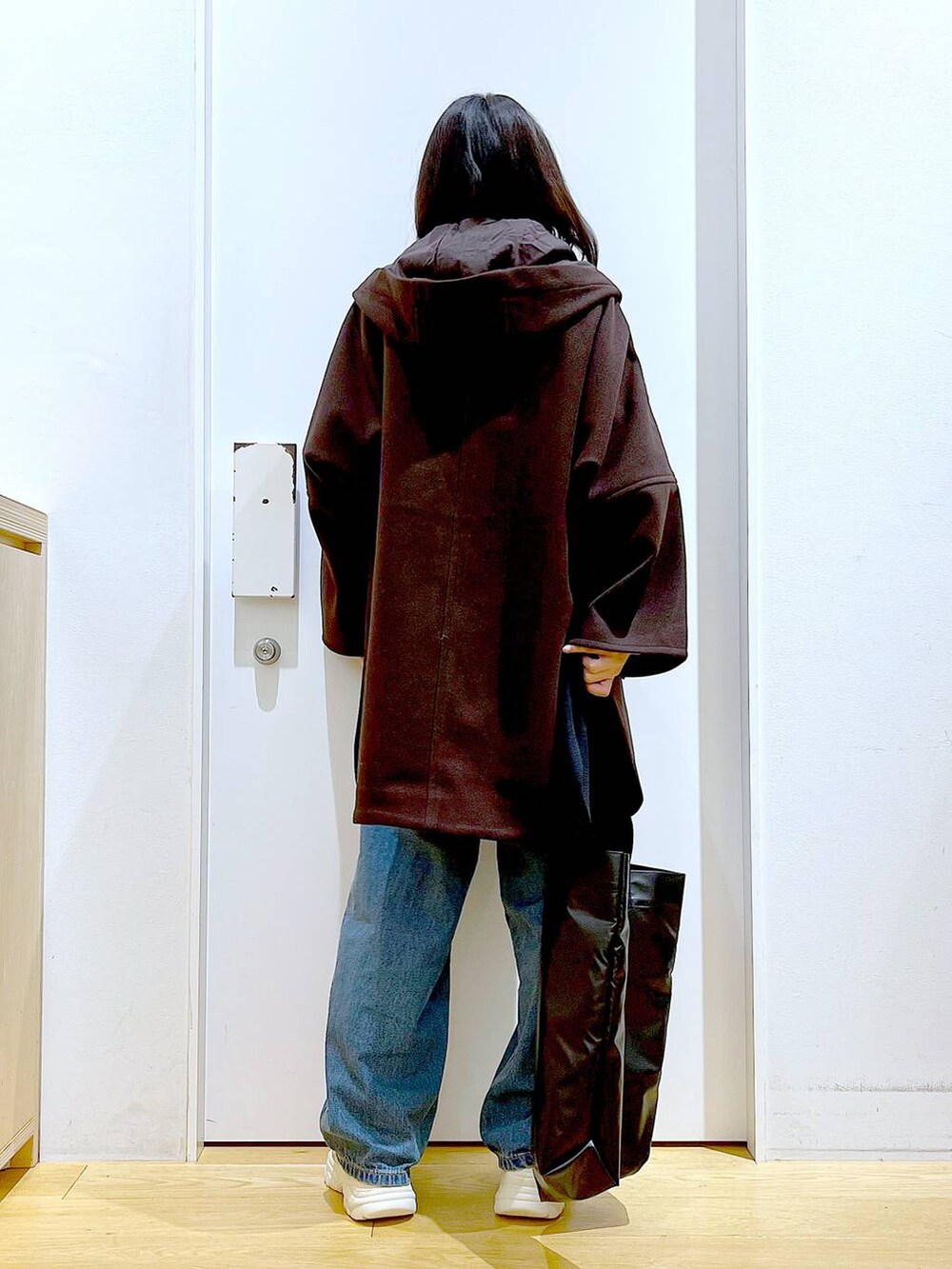 ブラウン系のその他アウター、ベージュ系のスニーカー、ブルー系のデニムパンツを着用したレディースの冬コーディネートの5枚目の写真