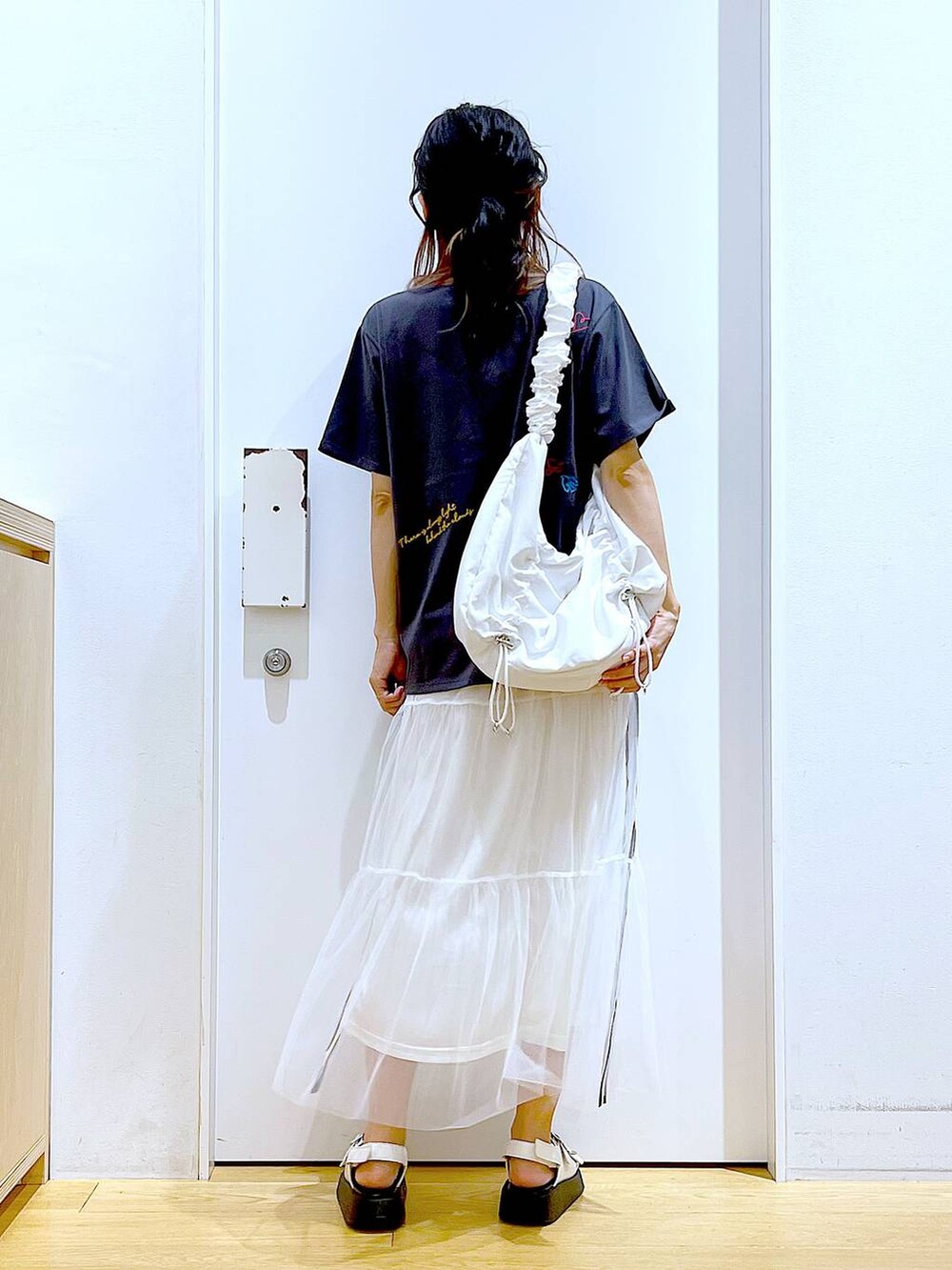 ホワイト系のサンダル、ホワイト系のショルダーバッグ、ホワイト系のスカートを着用したレディースの夏コーディネートの6枚目の写真