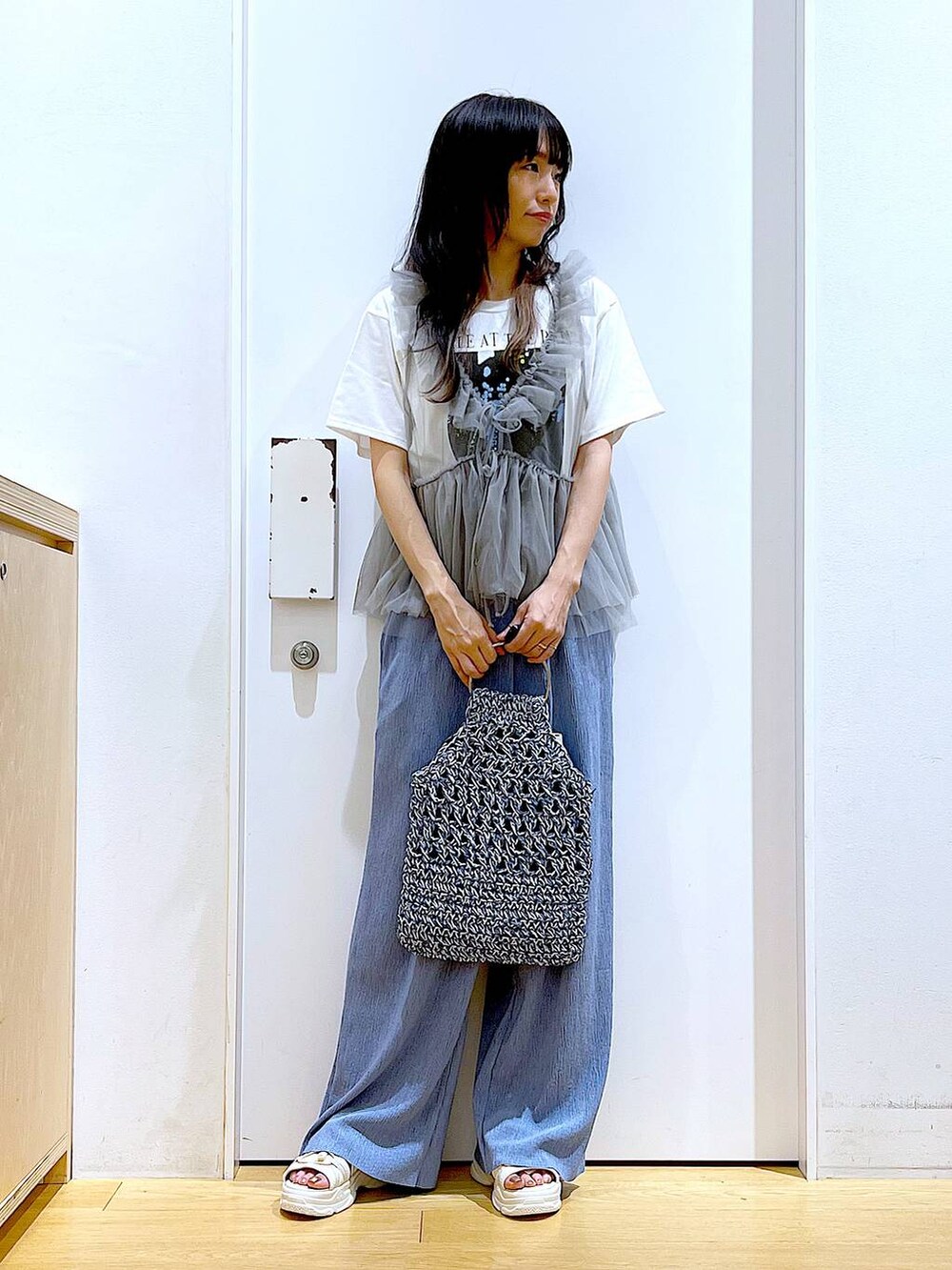 ホワイト系のサンダル、ブルー系のハンドバッグ、ブルー系のその他パンツを着用したレディースの夏コーディネートの2枚目の写真