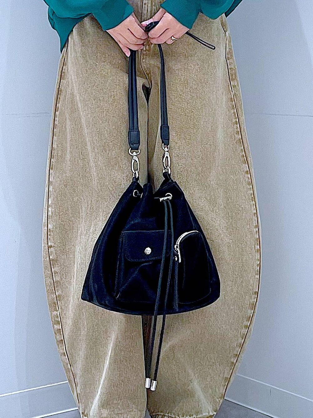 ベージュ系のデニムパンツ、ブラック系のショルダーバッグ、ブラック系のブーツを着用したレディースの冬コーディネートの9枚目の写真