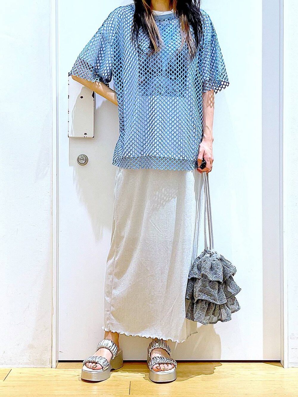 グレー系のスカート、シルバー系のショルダーバッグ、ホワイト系のTシャツ/カットソーを着用したレディースの夏コーディネートの6枚目の写真