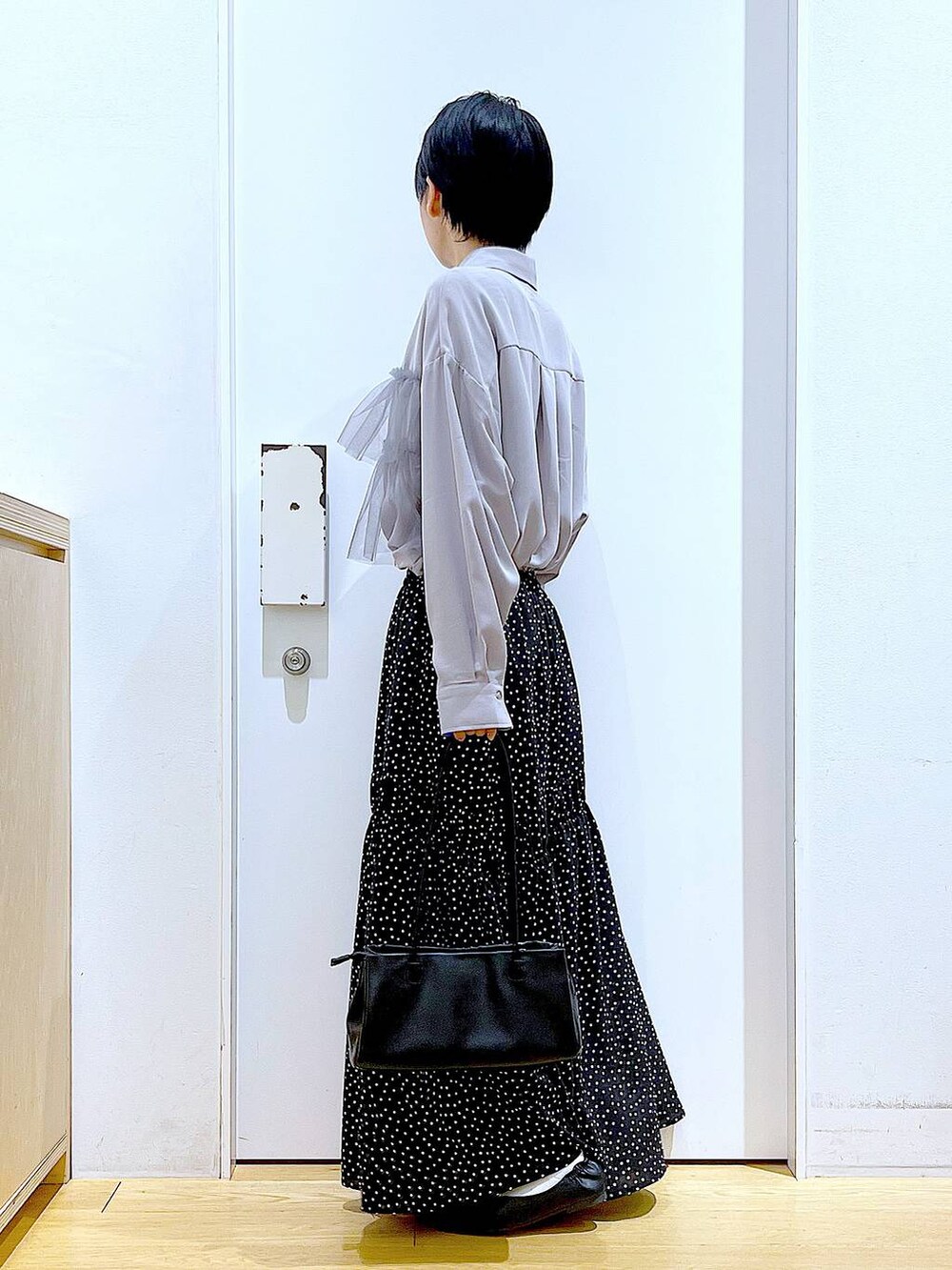 ブラック系のトートバッグ、ブラック系のパンプス、その他のスカートを着用したレディースの春コーディネートの3枚目の写真
